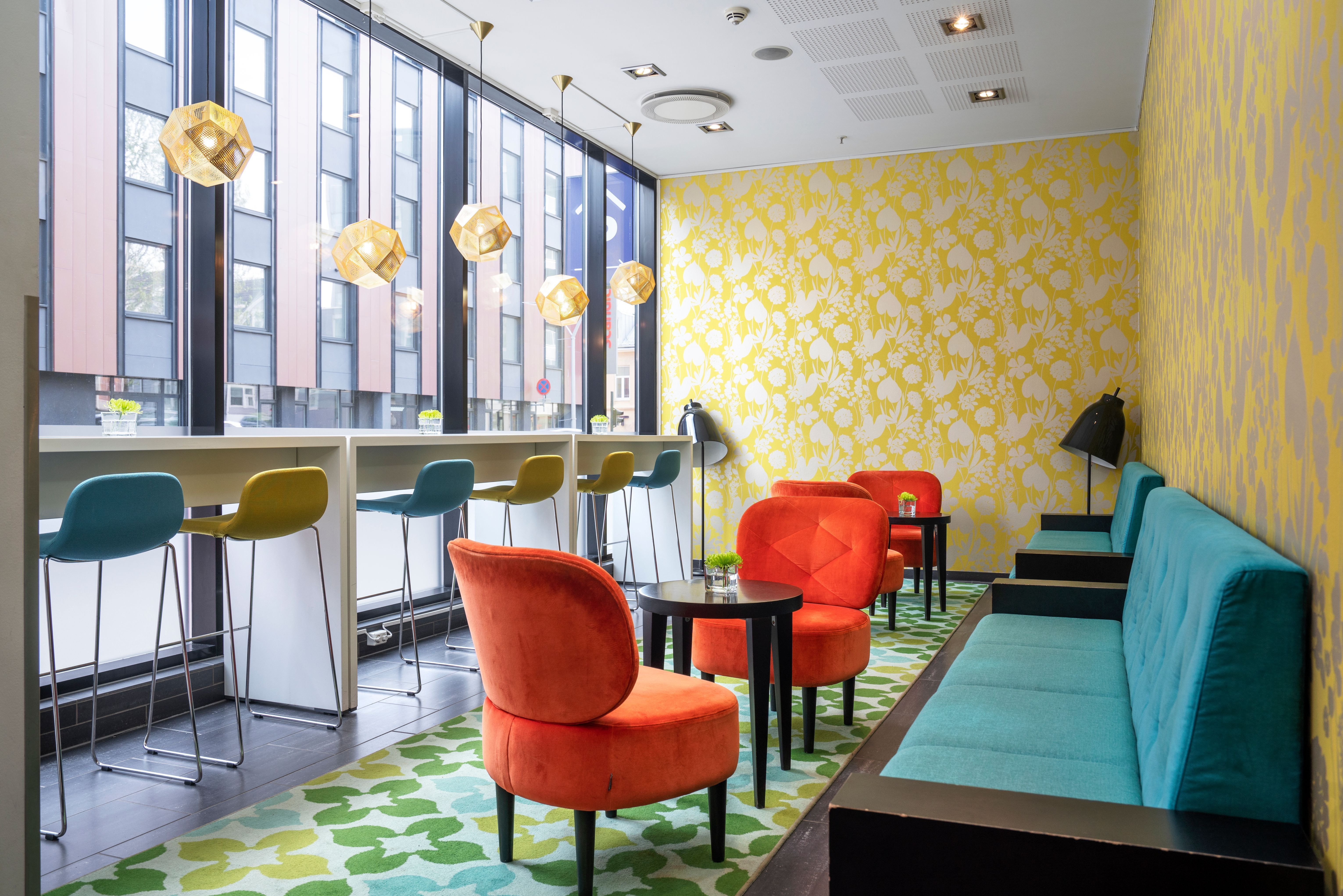 Colourful lounge with large windows, seating areas, and modern furnishings.