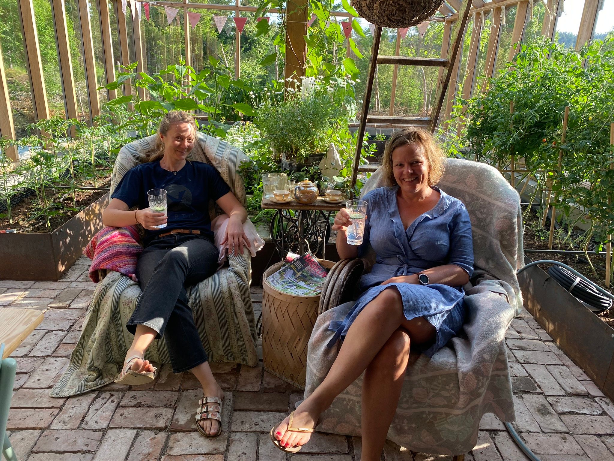 to damer som sitter å koser seg i en vinterhage