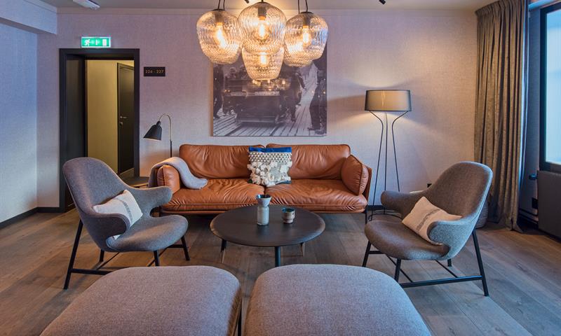 En sofa og stoler rundt et kaffebord i en salong