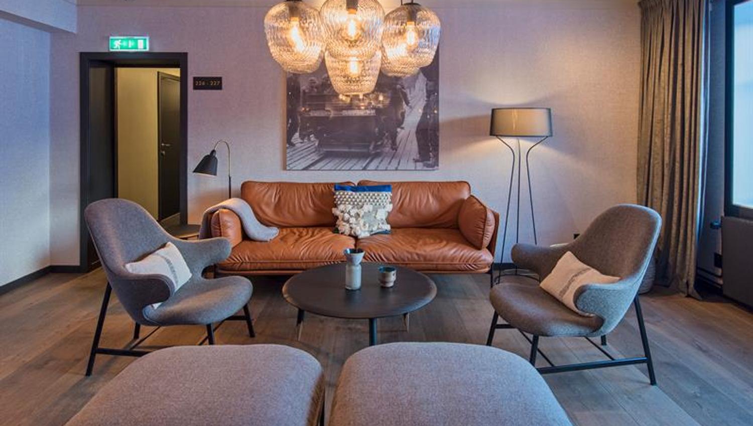 En sofa og stoler rundt et kaffebord i en salong