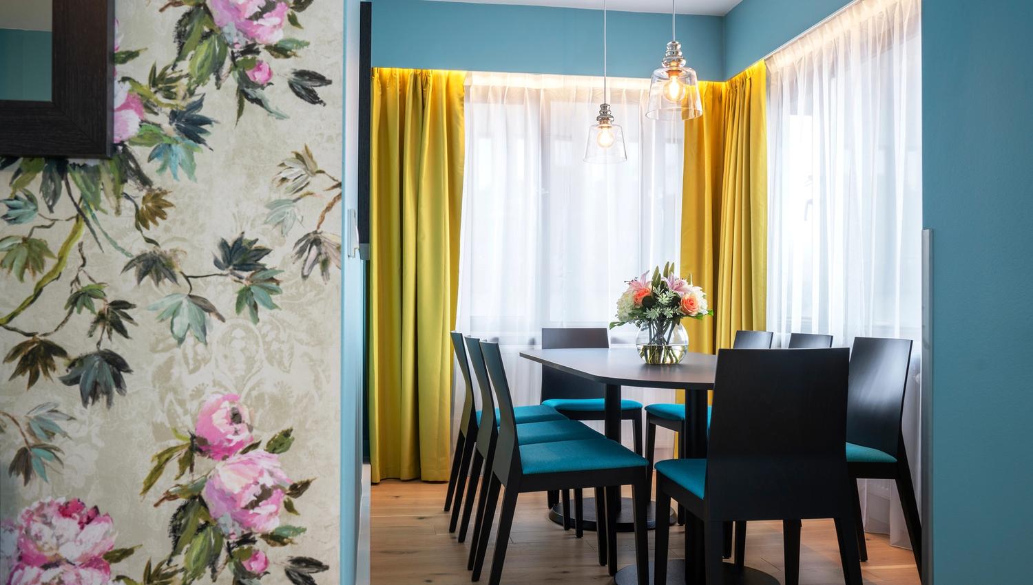 Møtebord med turkise stoler. Tapet med rosa blomster. Gule gardiner. Thon Hotel Slottsparken, Oslo. Foto
