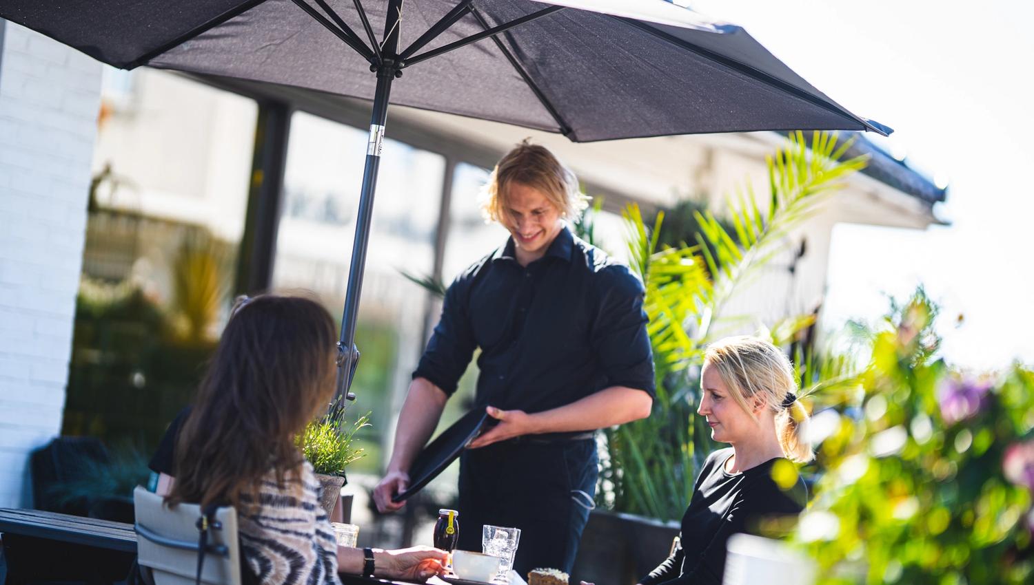 two woman having lunch and server taking order
