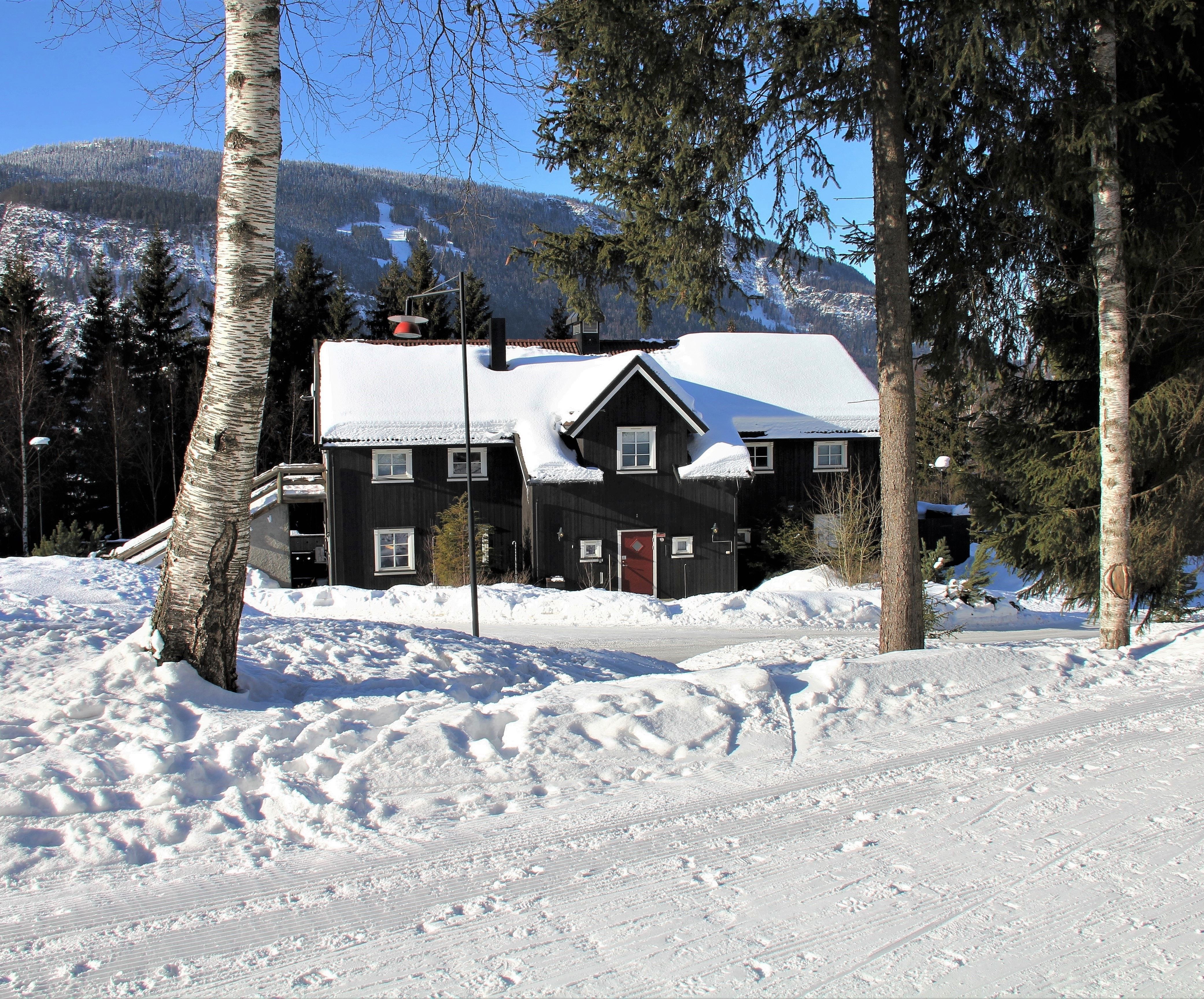The barn is a large cabin with snow on the roof.