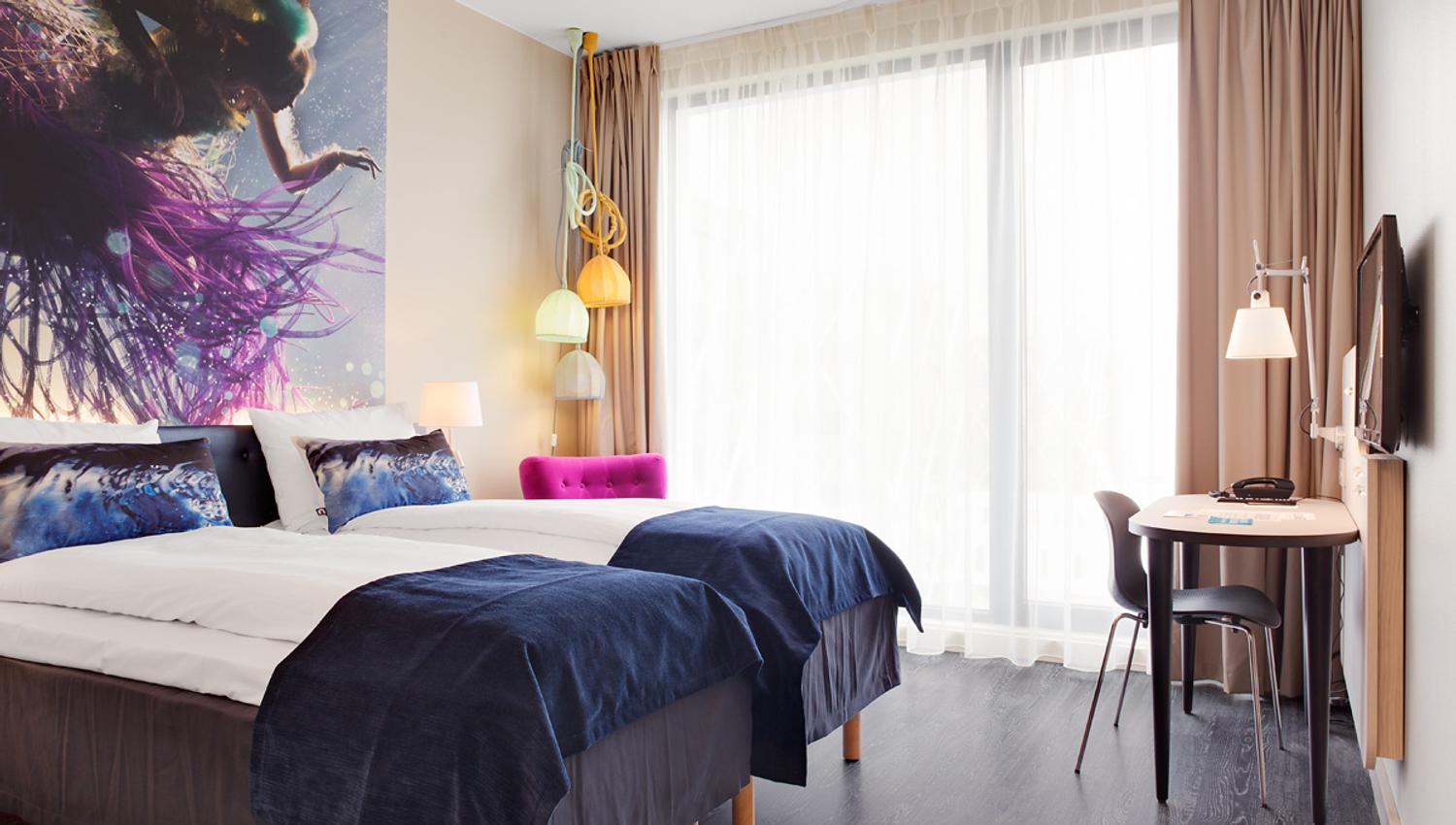 lyst dobbeltrom med to senger og skrivebord