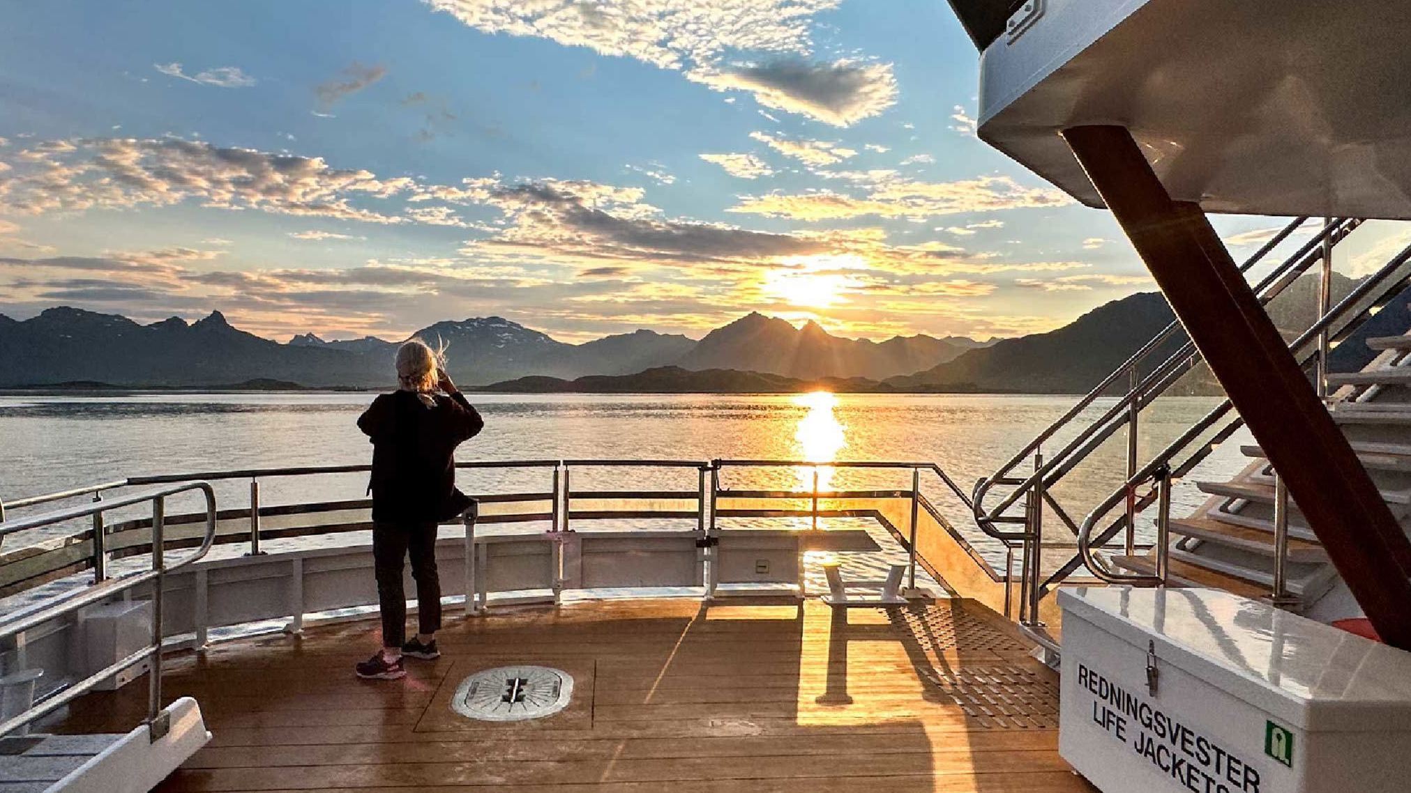 A guest looking at the midnight sun from the boat