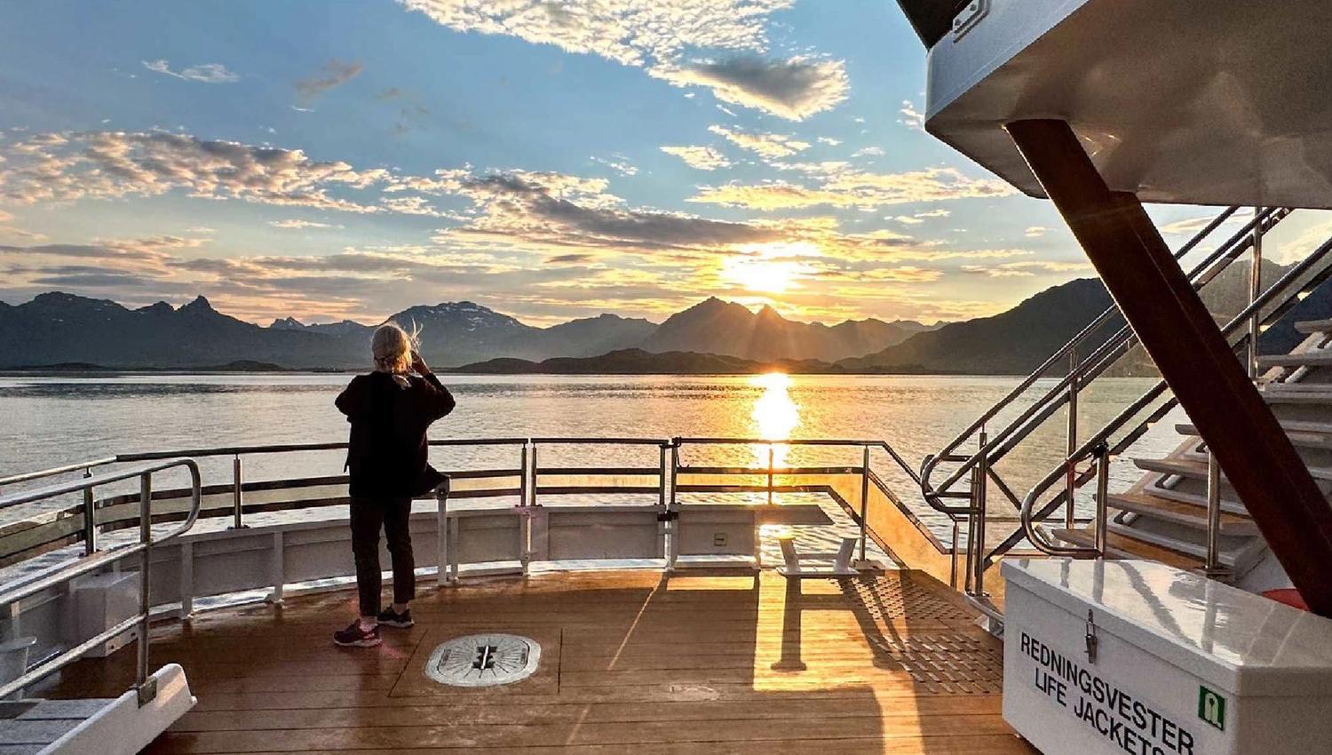 A guest looking at the midnight sun from the boat