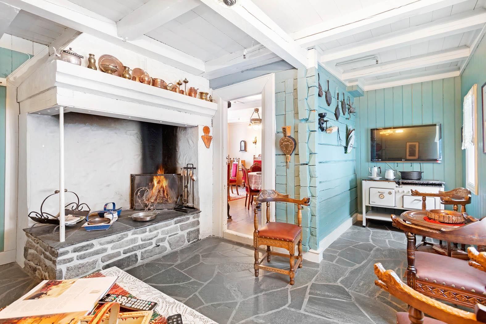 Koseleg stove med open peis og tradisjonelt interiør på Jaunsen Gjestgjevarstad i Hardanger.