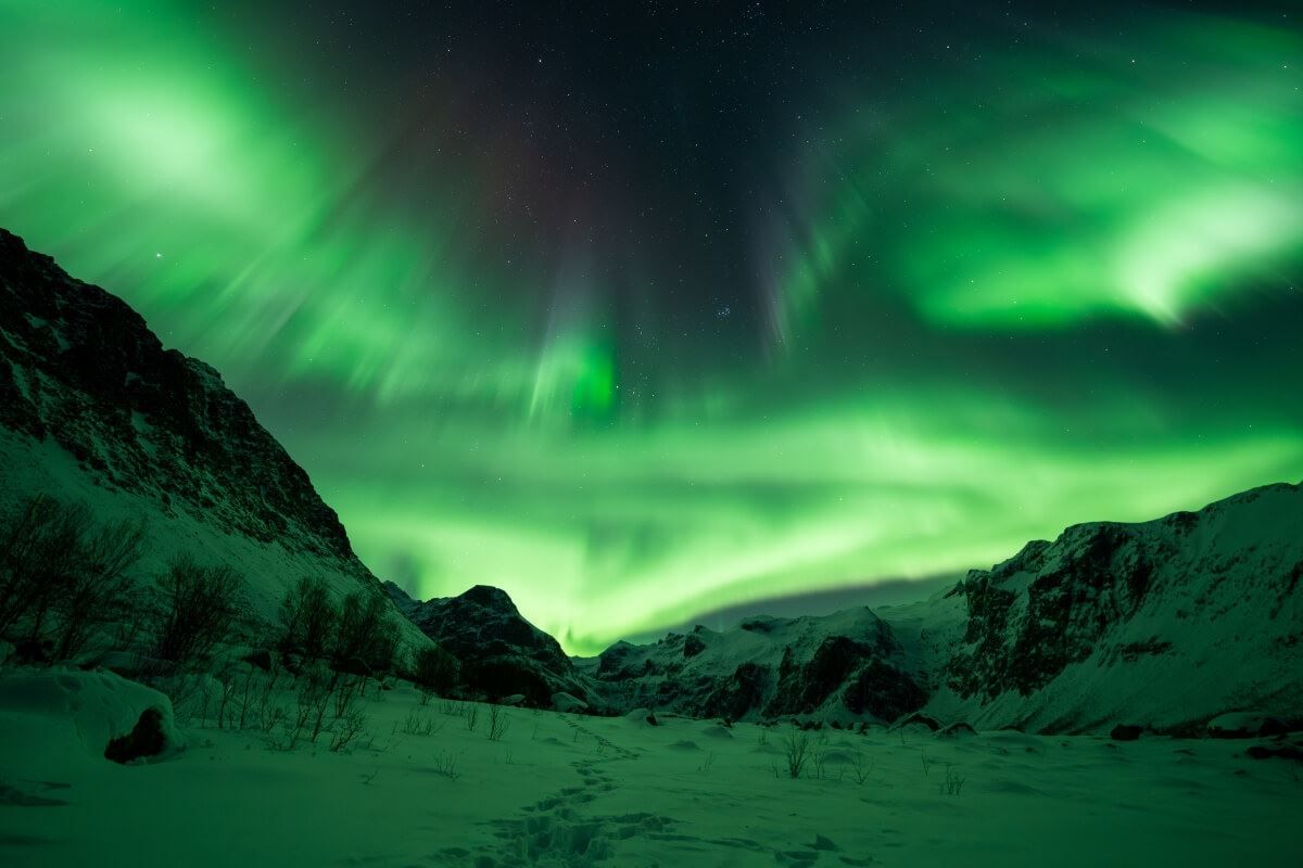 Nordlyset skinner ut siden av et fjell