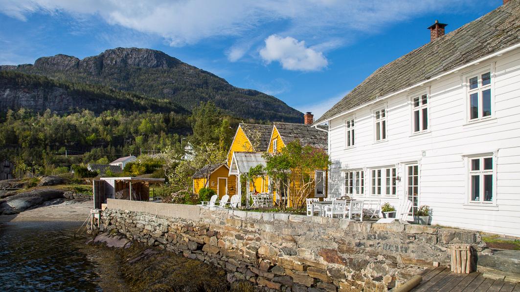 Kramsjø Guesthouse in Hardanger – charming white and yellow waterfront houses surrounded by fjord scenery and majestic mountains.