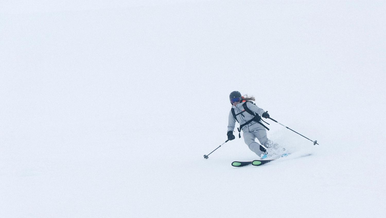 En kvinne på ski nedover en bakke.