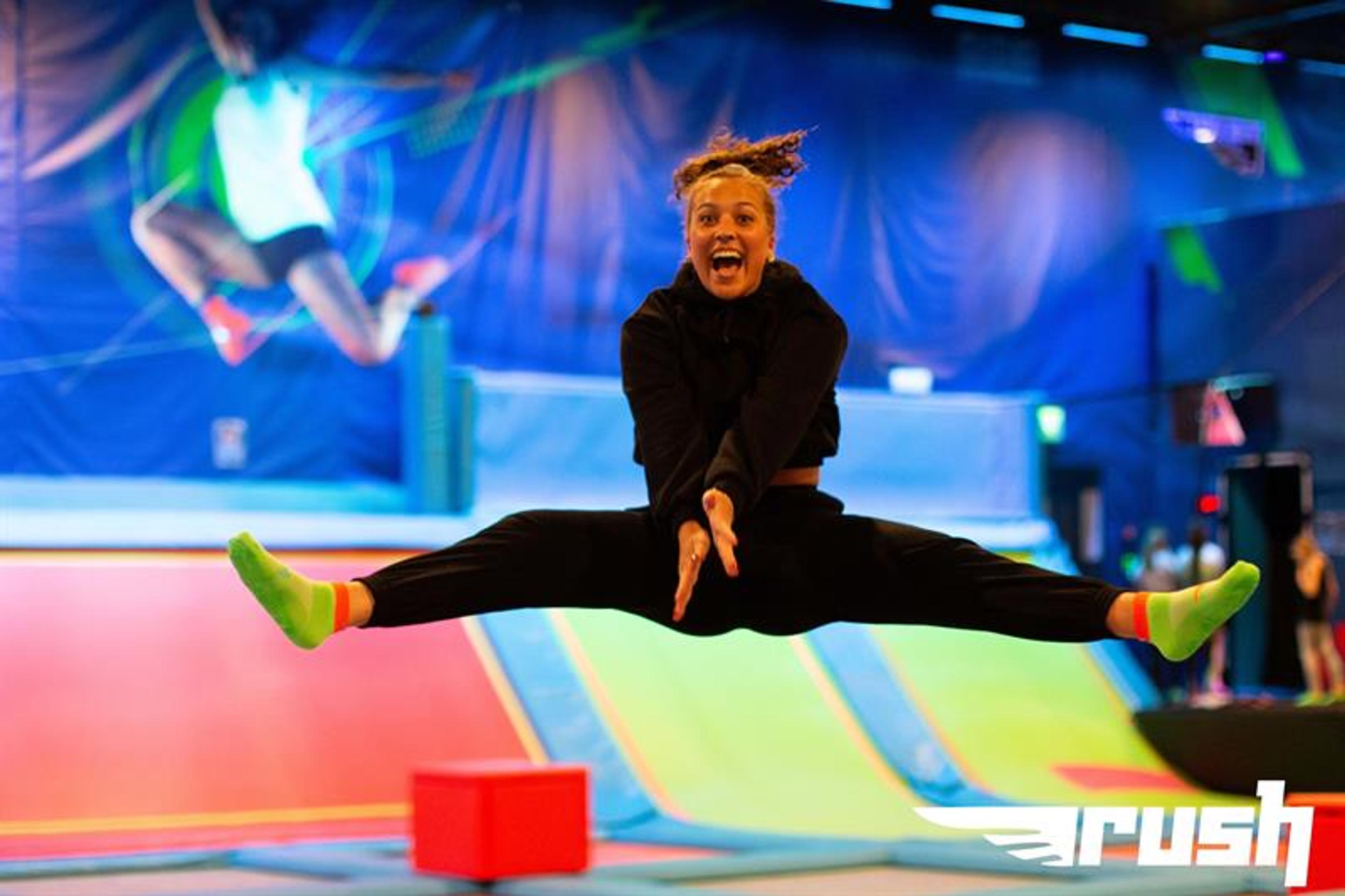 Girl taking a split jump on a trampoline.