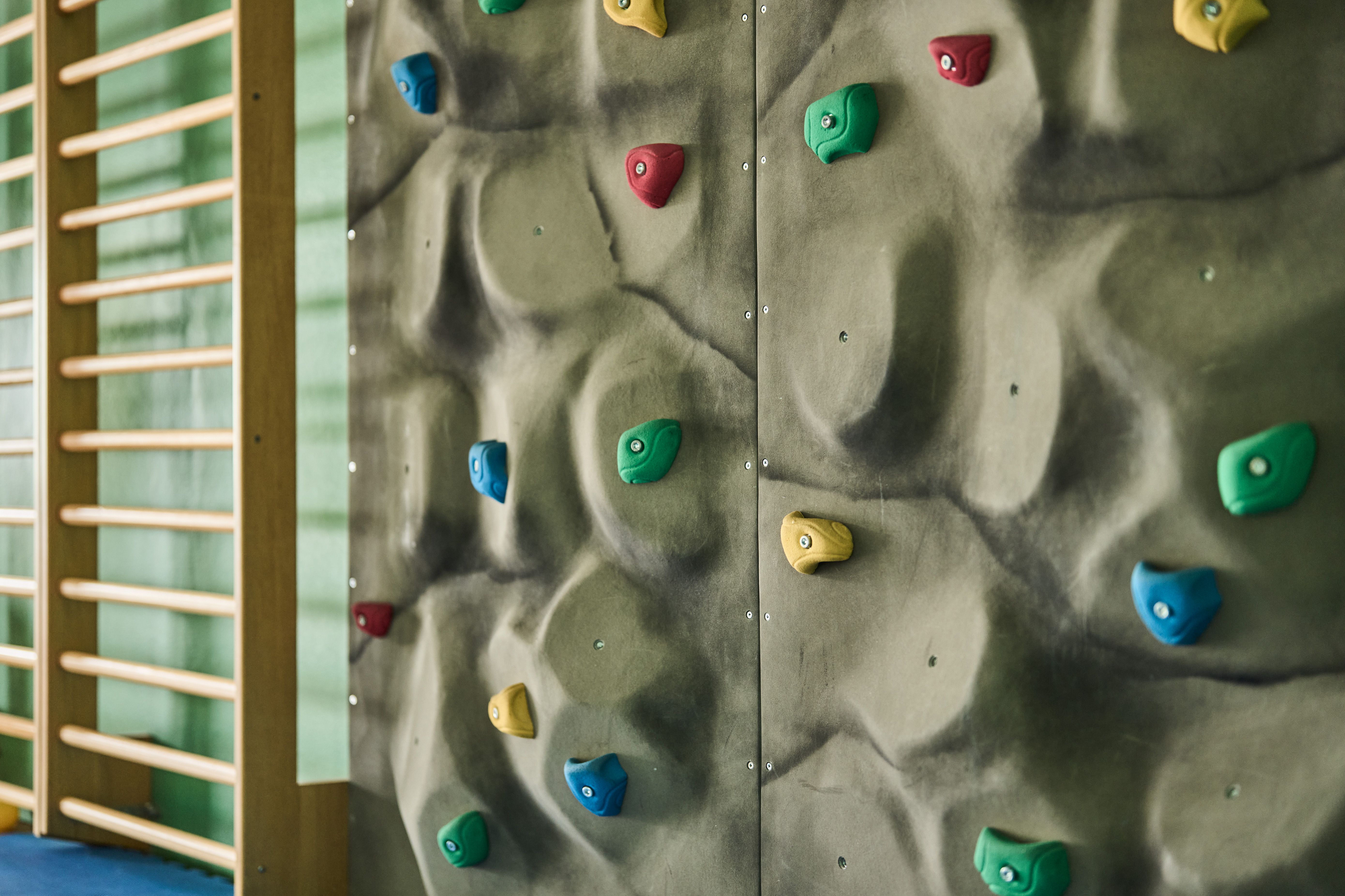 Fargerik klatrevegg i aktivitetsområdet på Hotel Ullensvang – moro for små og store.