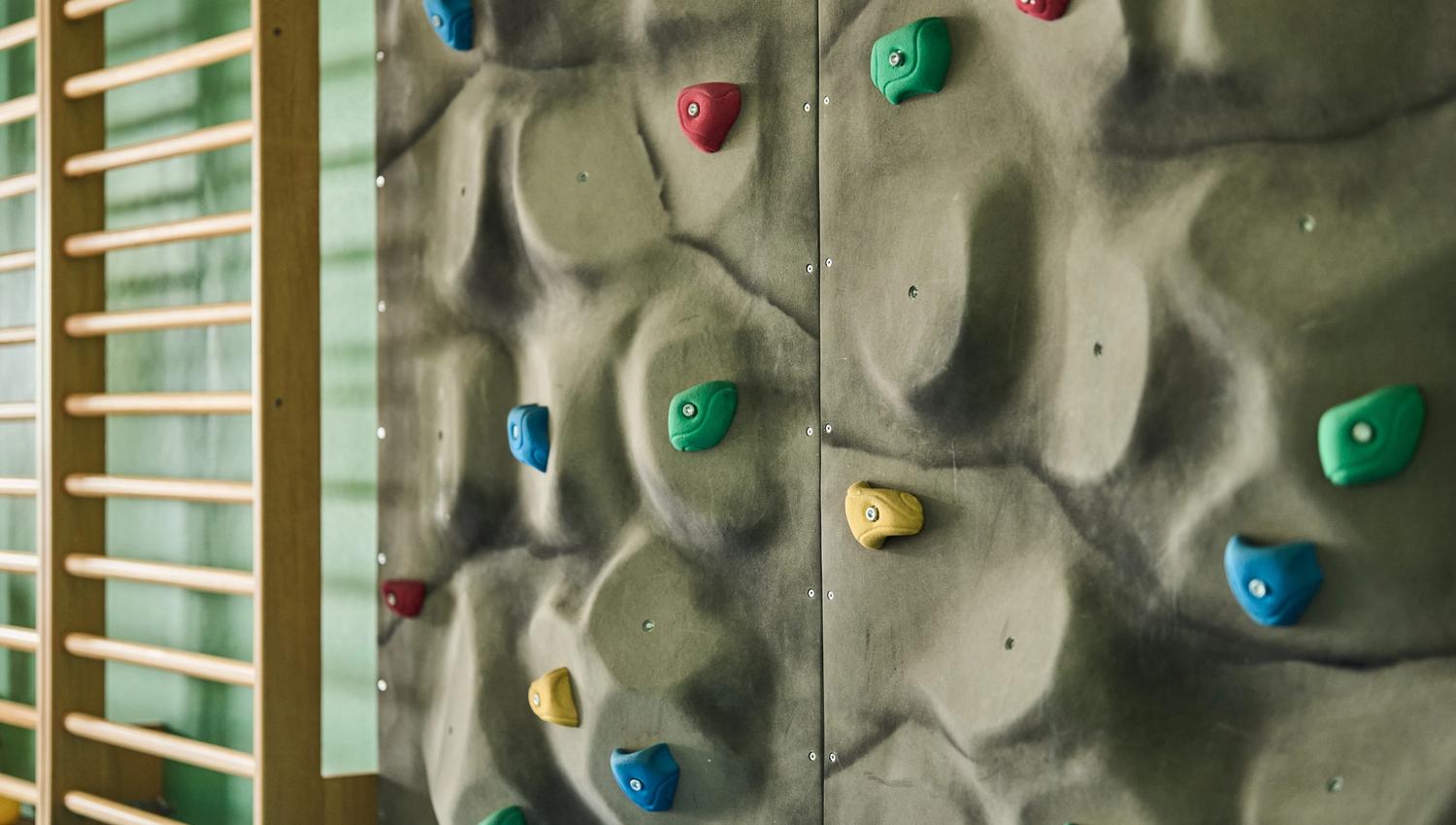 Fargerik klatrevegg i aktivitetsområdet på Hotel Ullensvang – moro for små og store.