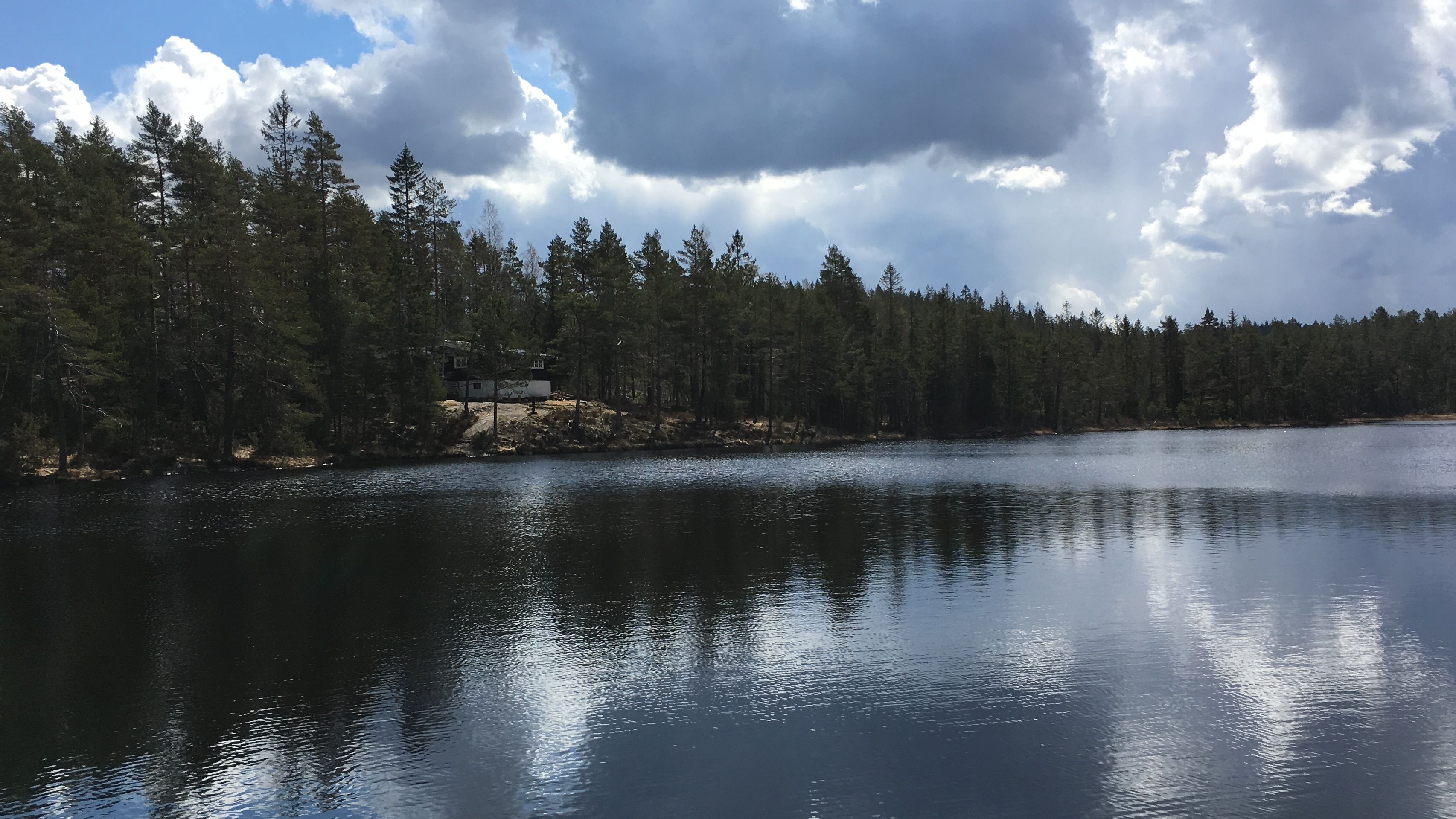 utsikt over stille tjern og hytte