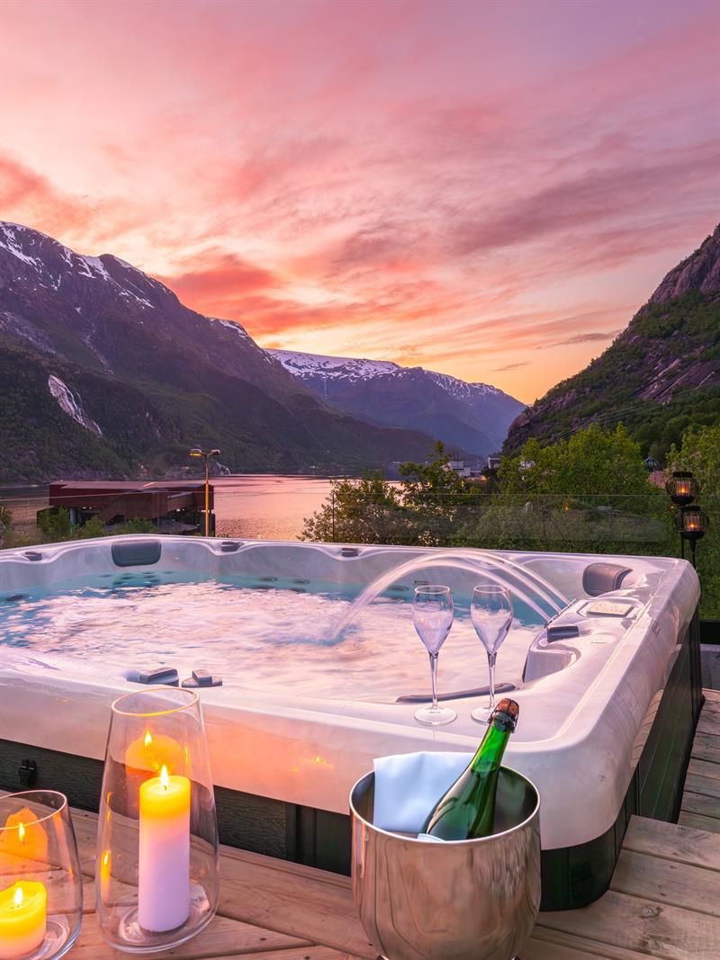 Jacuzzi at Tyssedal Hotel with fjord view at sunset.