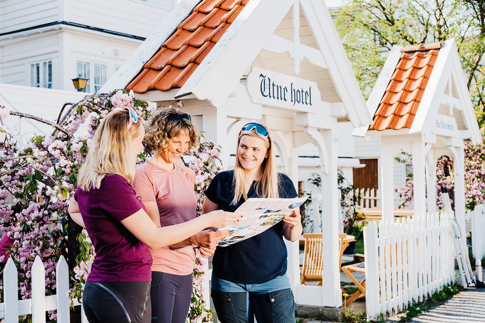 Three hikers planning an adventure in Hardanger outside the charming Utne Hotel.