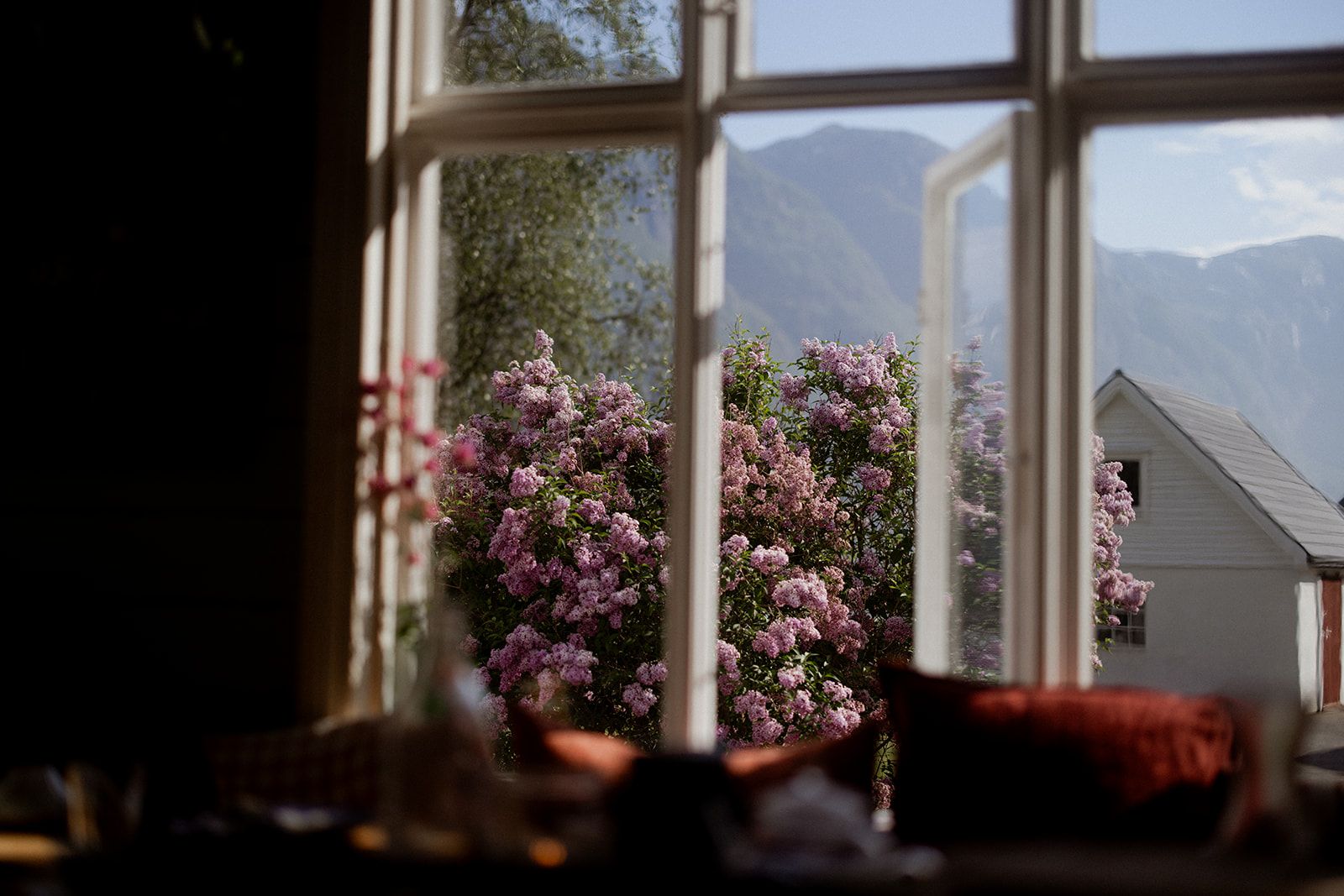 View of blooming lilacs from the lounge at Hotel Sundal – springtime in the fjord landscape.