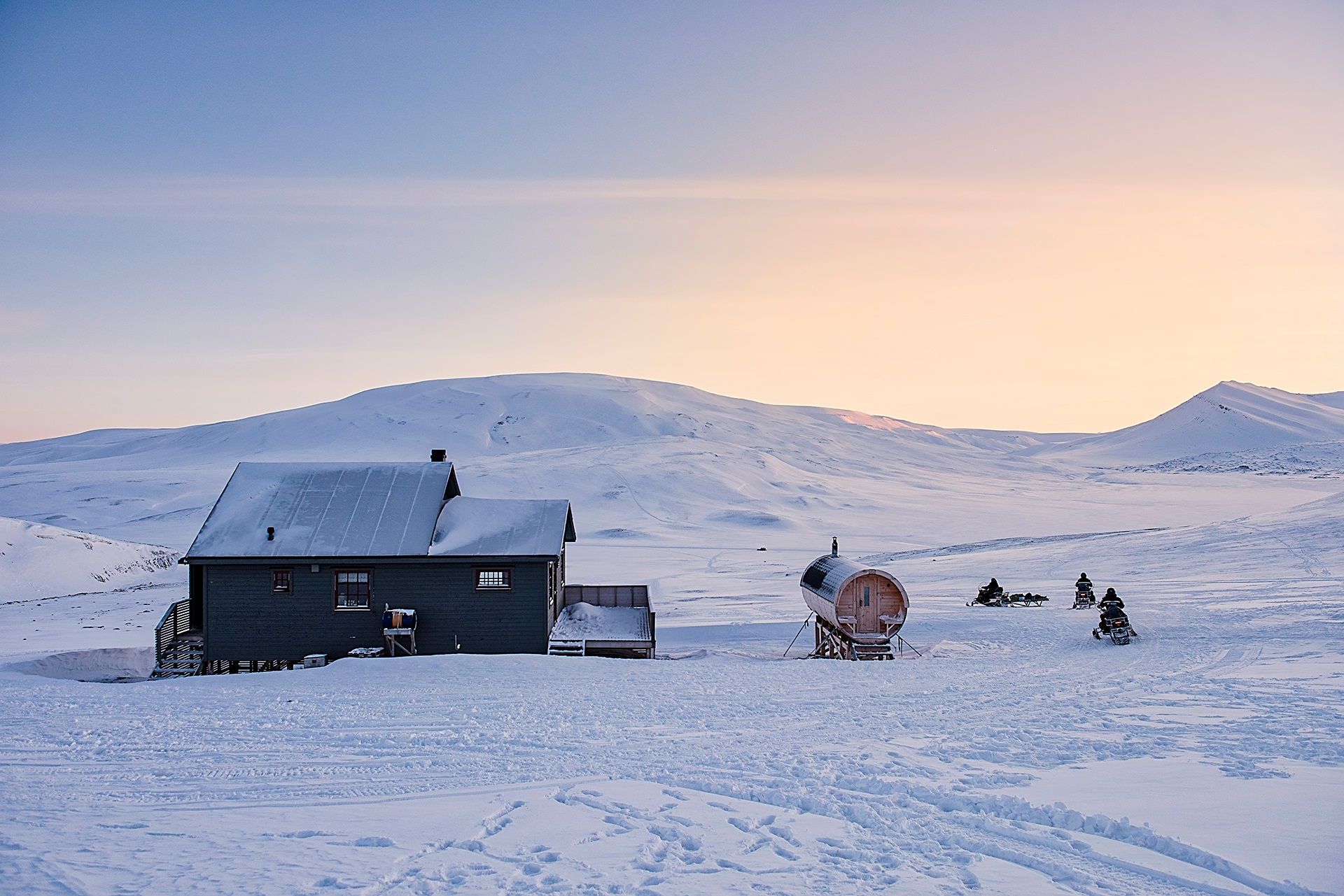 People on snowmobiles outside Juva Cabin