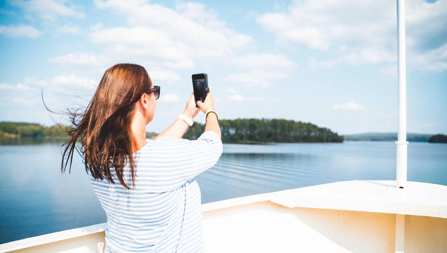 Dame som fotograferer ombord på MS Brekke