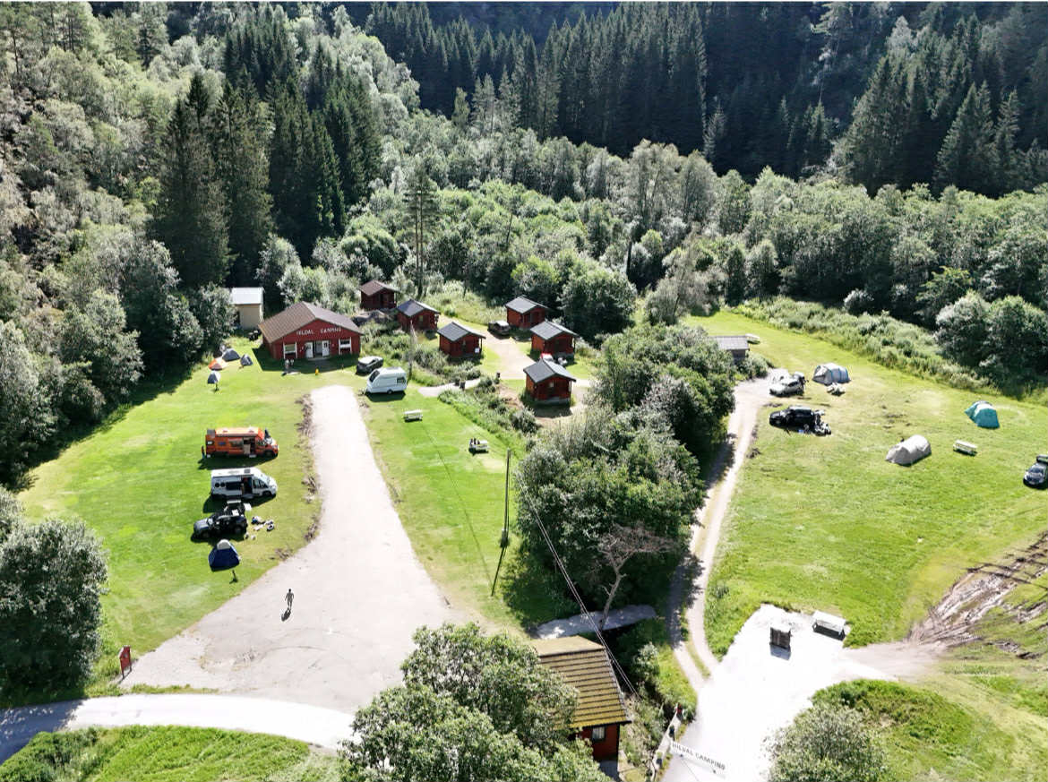Flyfoto av Hildal Camping med hytter, teltplassar og grøne omgjevnader i Hardanger.