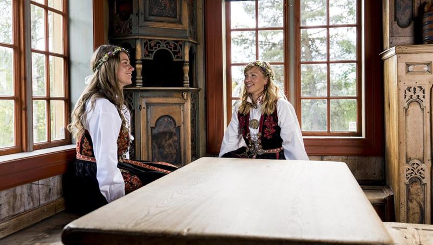 To bunadskledte jenter i Juvestoga, bygdetunet, Vest-Telemark museum Eidsborg.