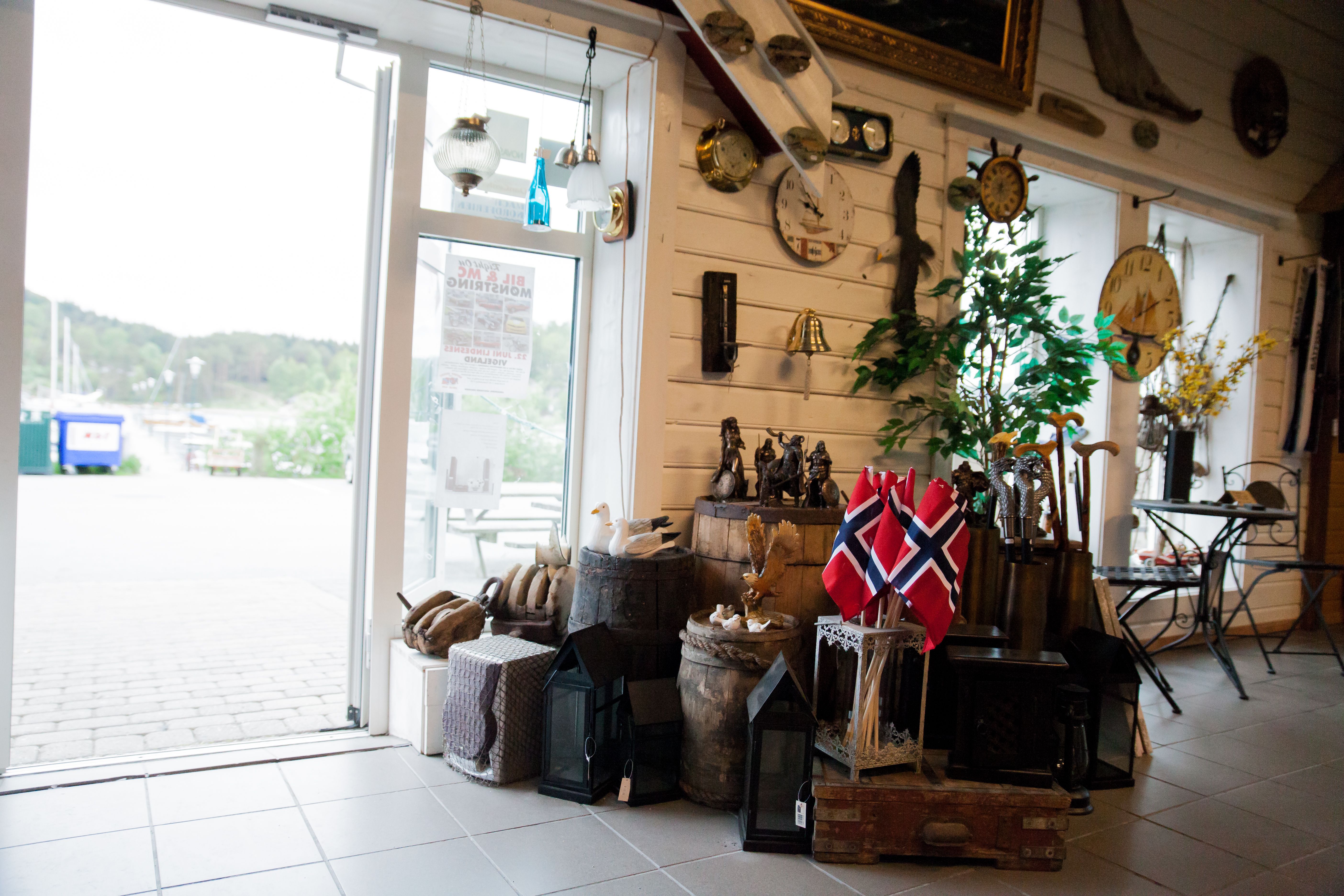 Inngangspartiet, pyntet med mange gamle tønner, kofferter, kasser. Norske småflagg, og stokker man kan kjøpe.