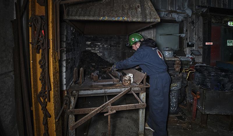 A guest on a guided tour of Mine 3 having a look at the forge inside the mine
