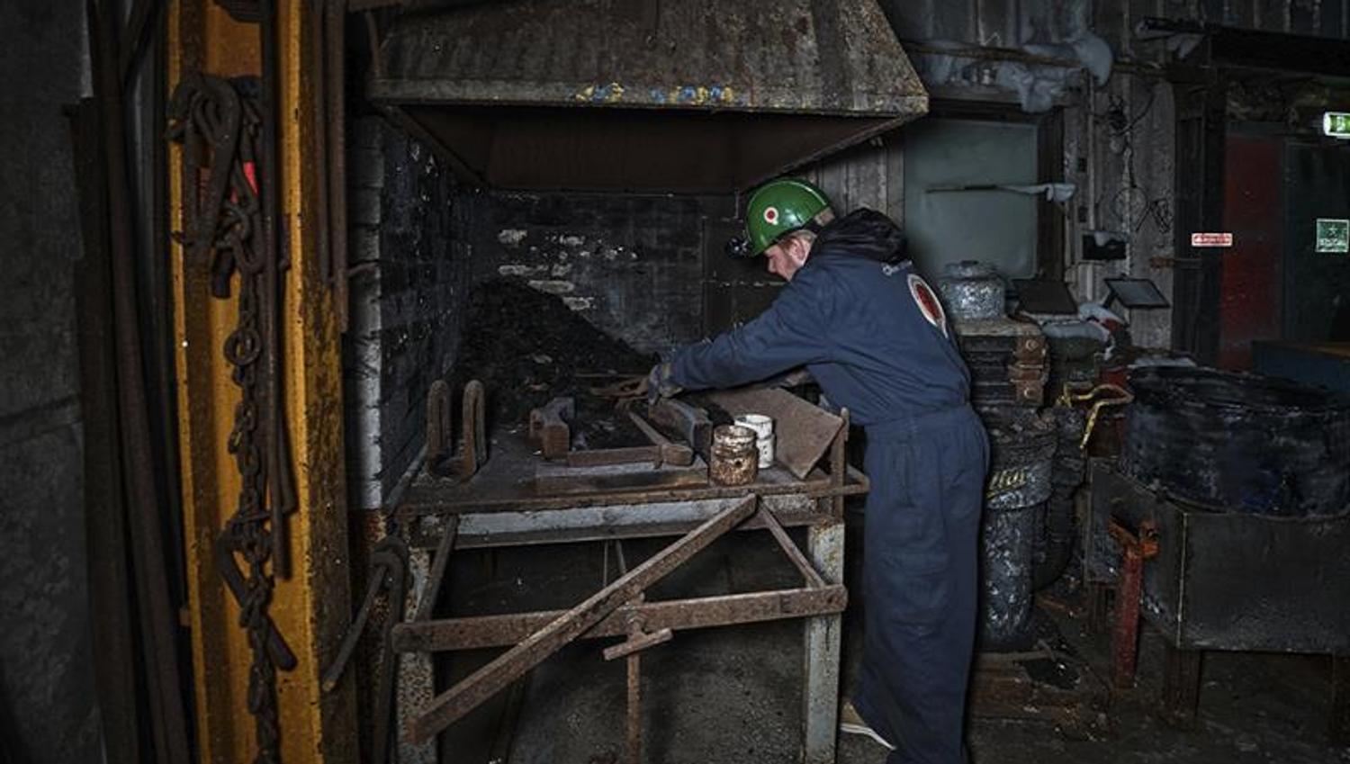 A guest on a guided tour of Mine 3 having a look at the forge inside the mine