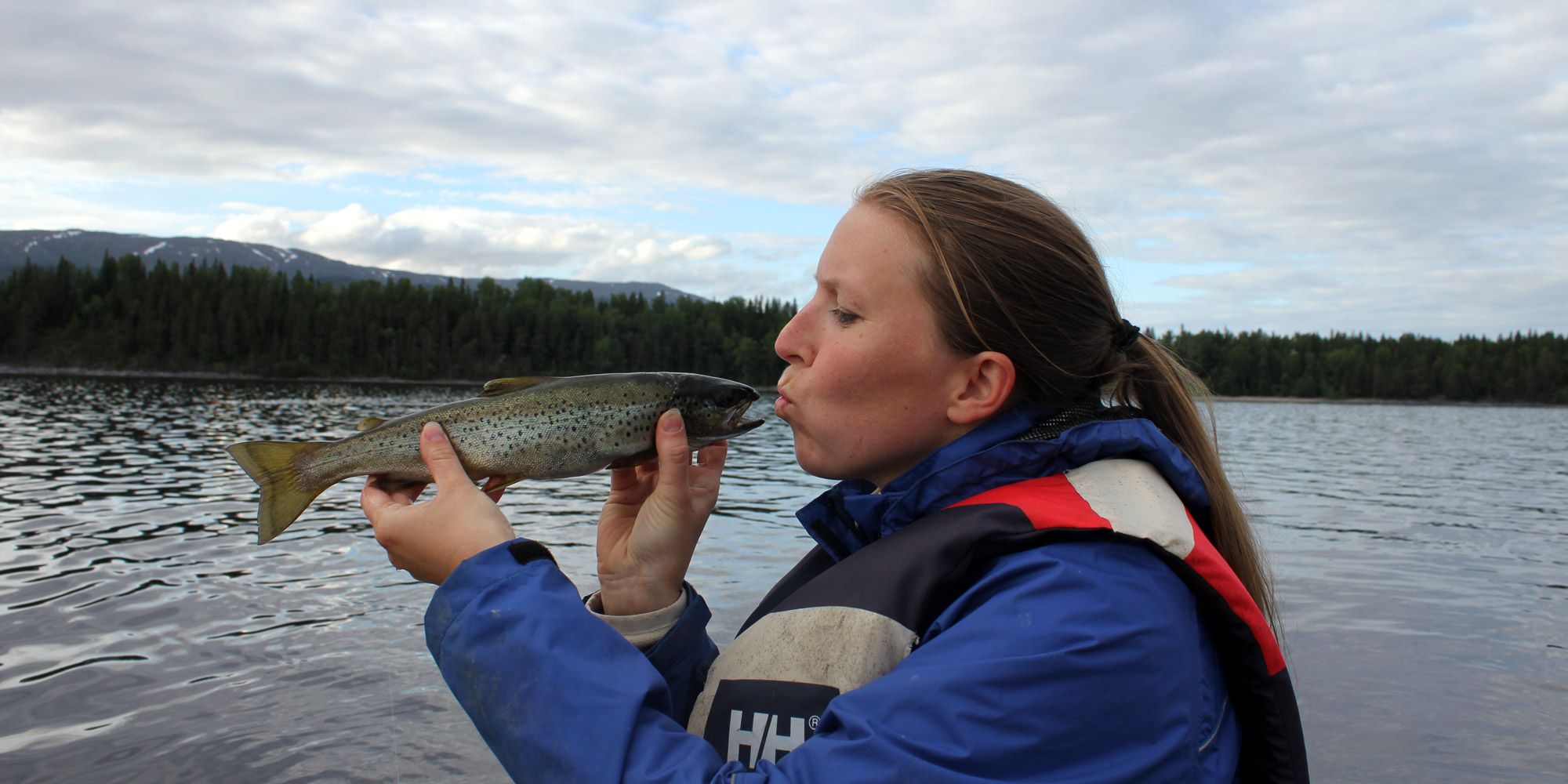 Christine has caugh a fish in Lake Snåsavatnet close to Oldernæs Strandcamp
