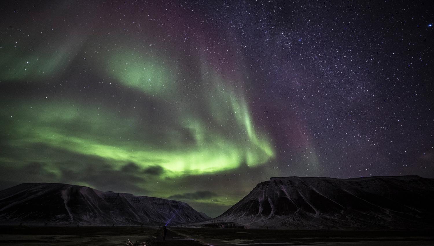 Nordlys som skinner over fjell