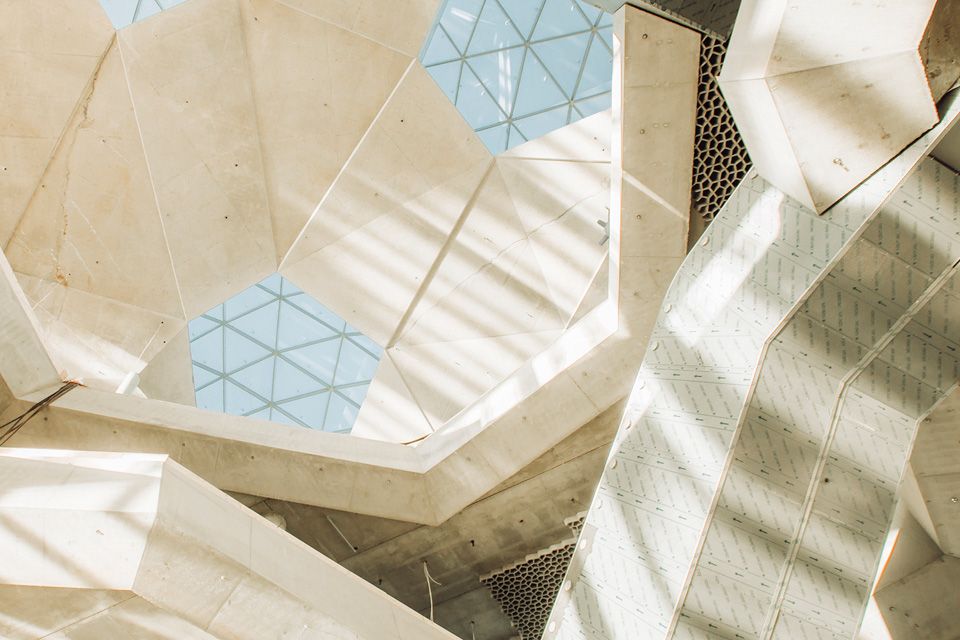 The ceiling inside the library Deichman Bjørvika, taken from below. The sky is visible through pentagonal window scattered across the ceiling full of 