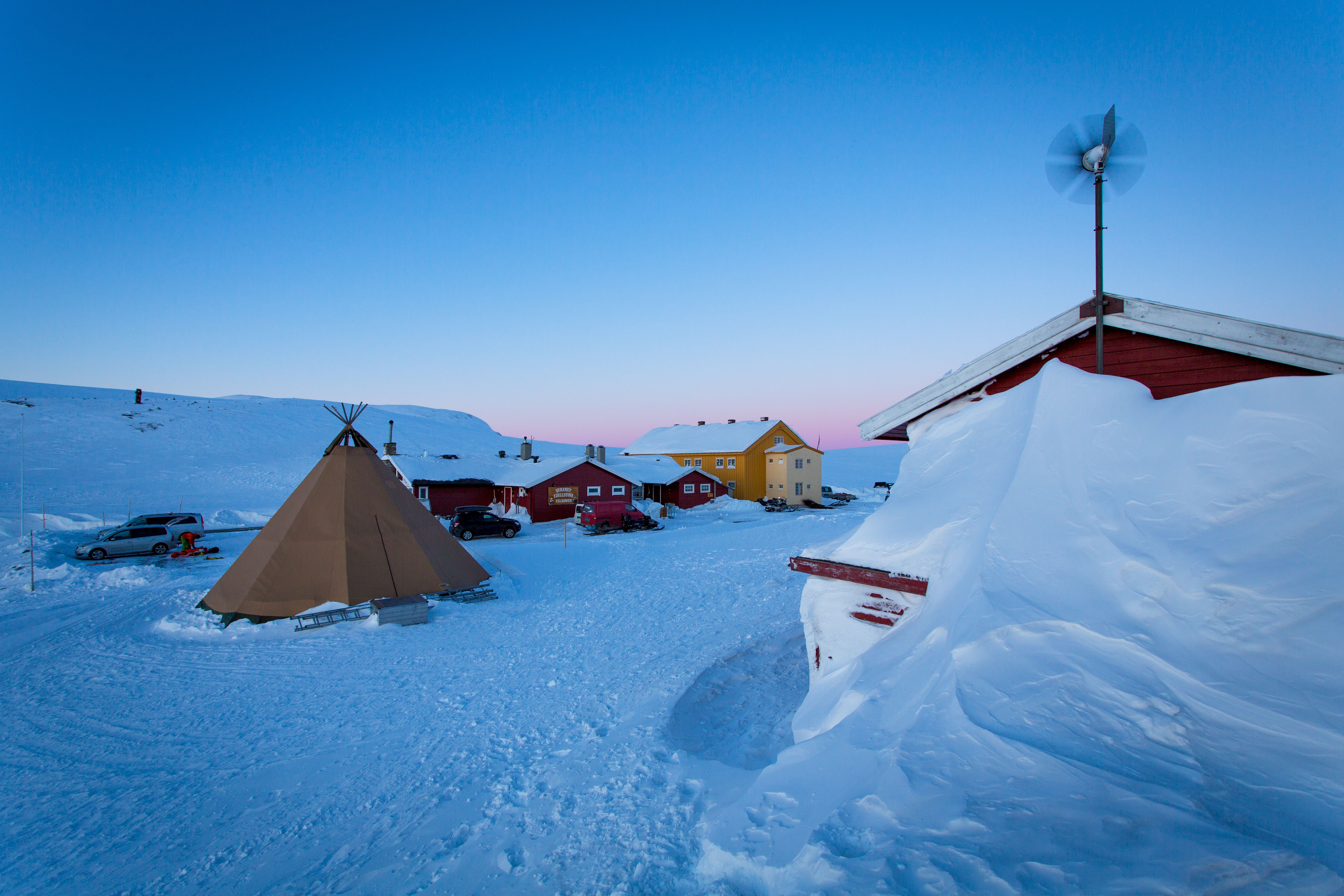 Den røde Dyranut Fjellstova og gule Dyranut Turisthytta i snølandskap.