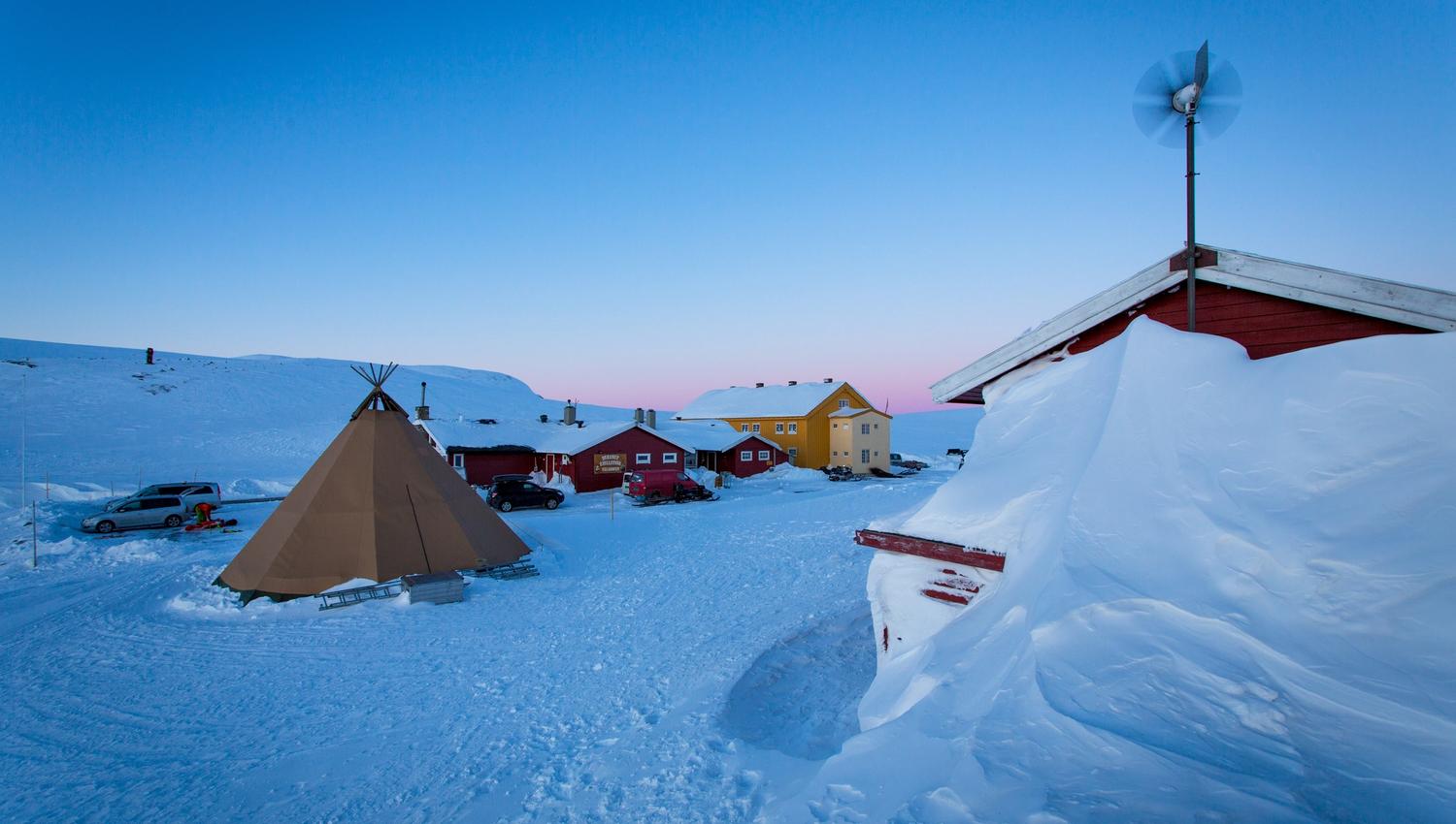 Den røde Dyranut Fjellstova og gule Dyranut Turisthytta i snølandskap.