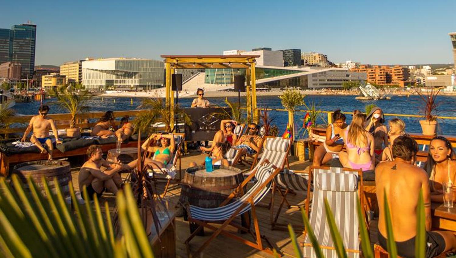 People in swimwear on the fjord terrace in front of the Opera House and the fjord