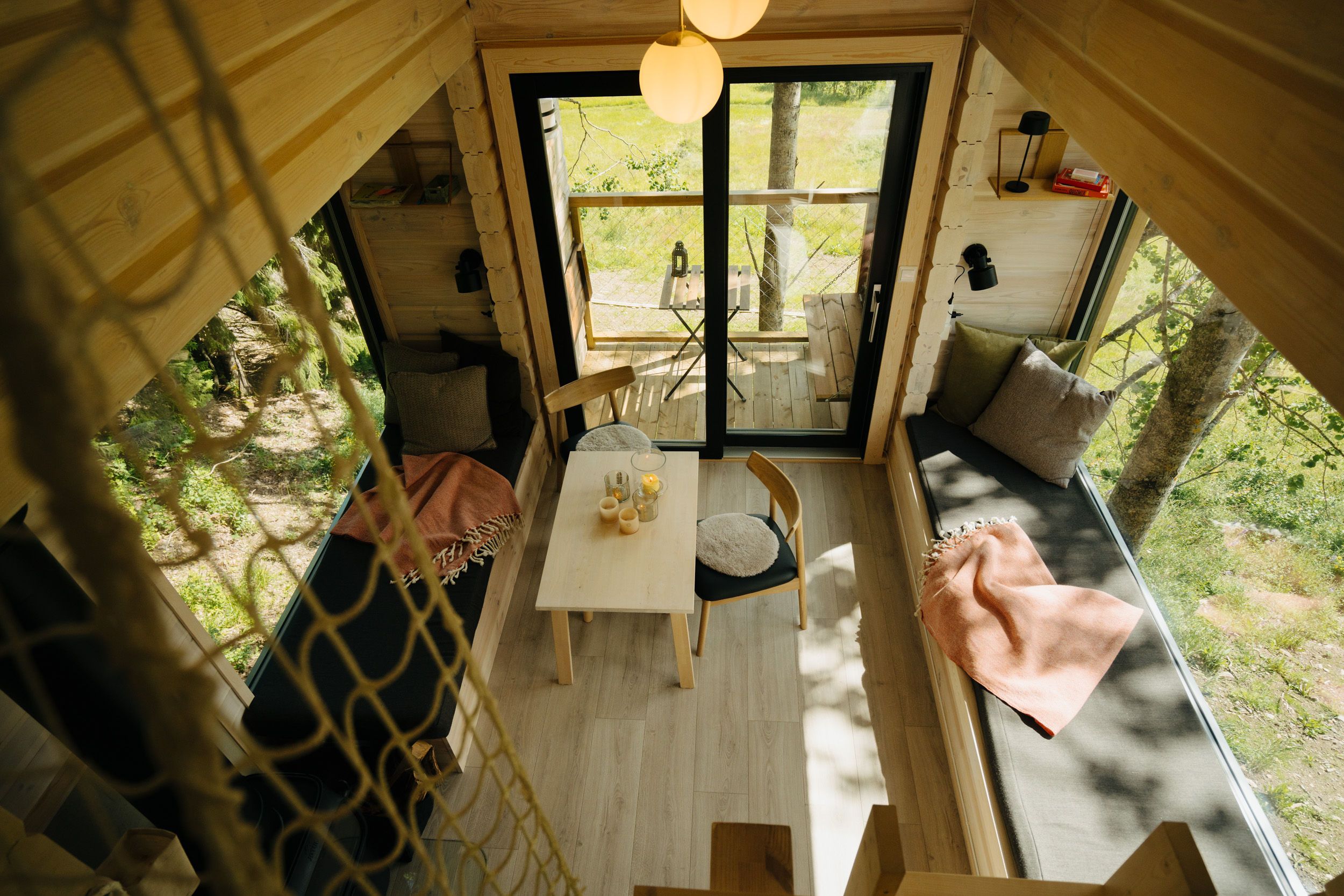 Chairs and a table in a room with large windows and scenic views outside.