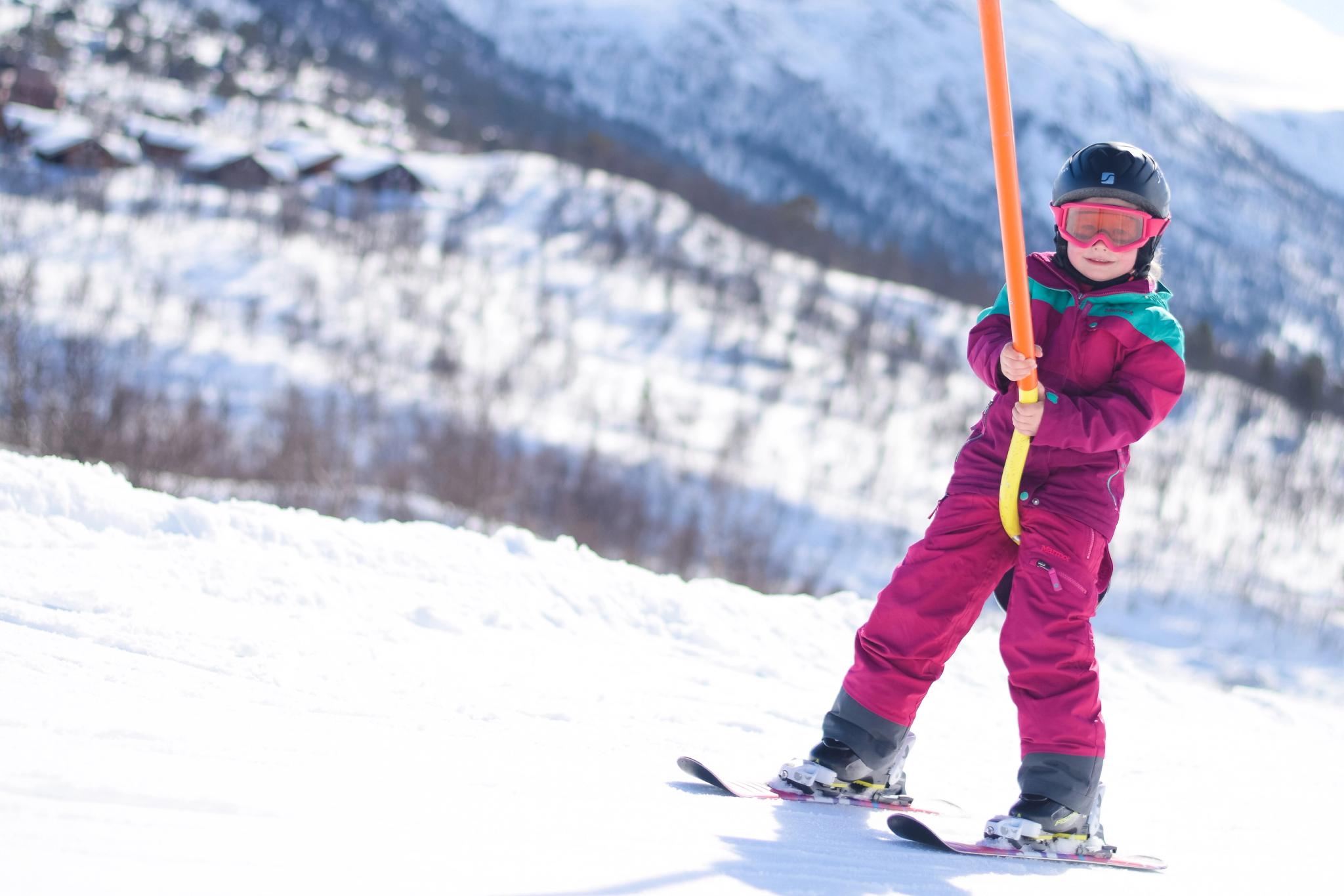 Girl using the ski tow in the children's skiing area, photo