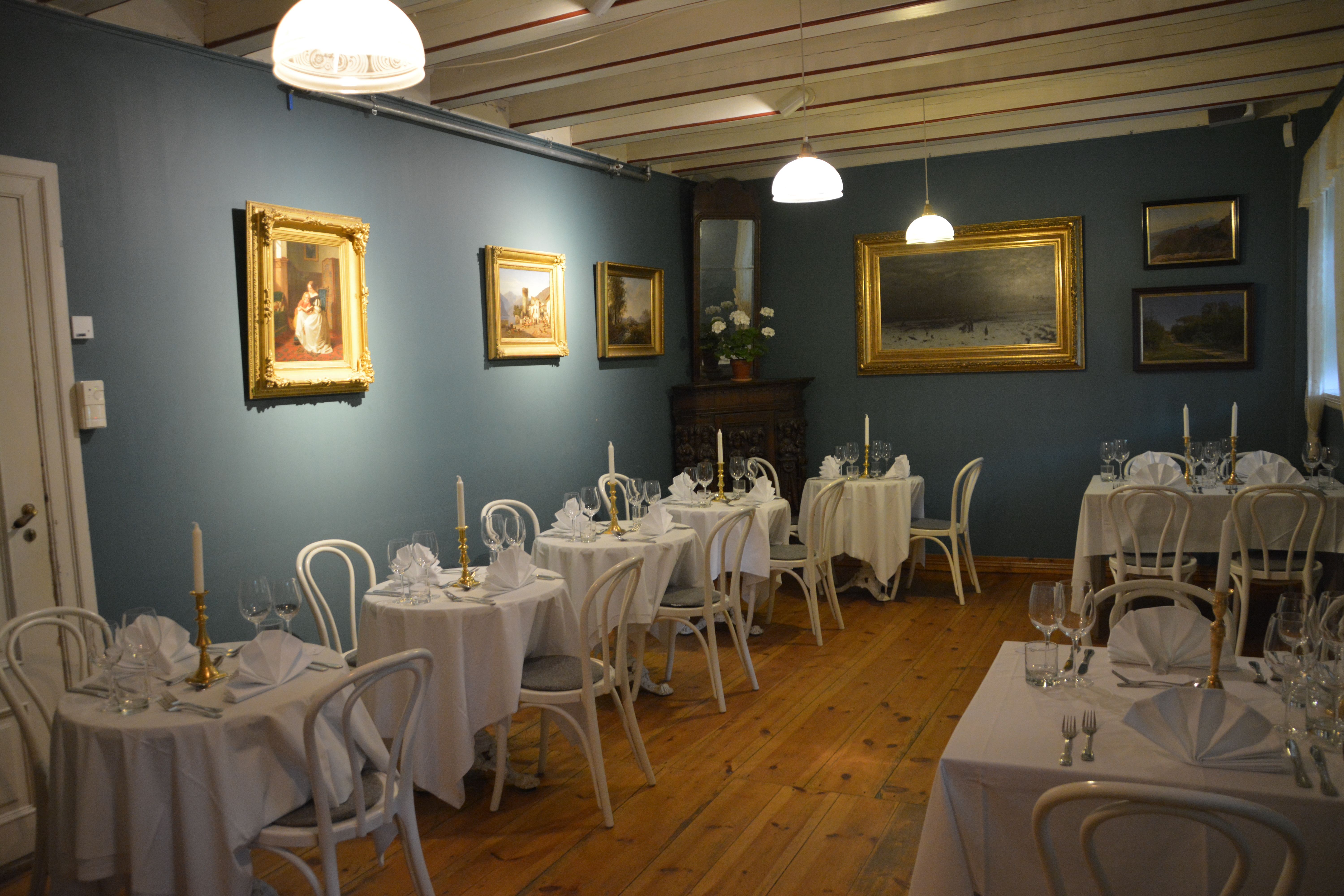 Den elegante spisesalen i Baroniet i Rosendal, dekka til for gjester med stilfull kunst på veggane.