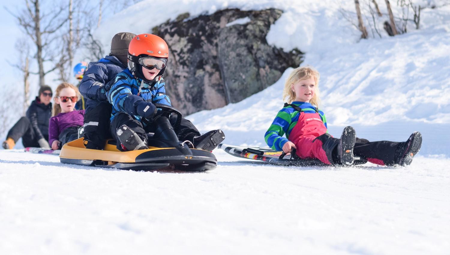 Barn renner på akebrett på alpinsenteret, bilde