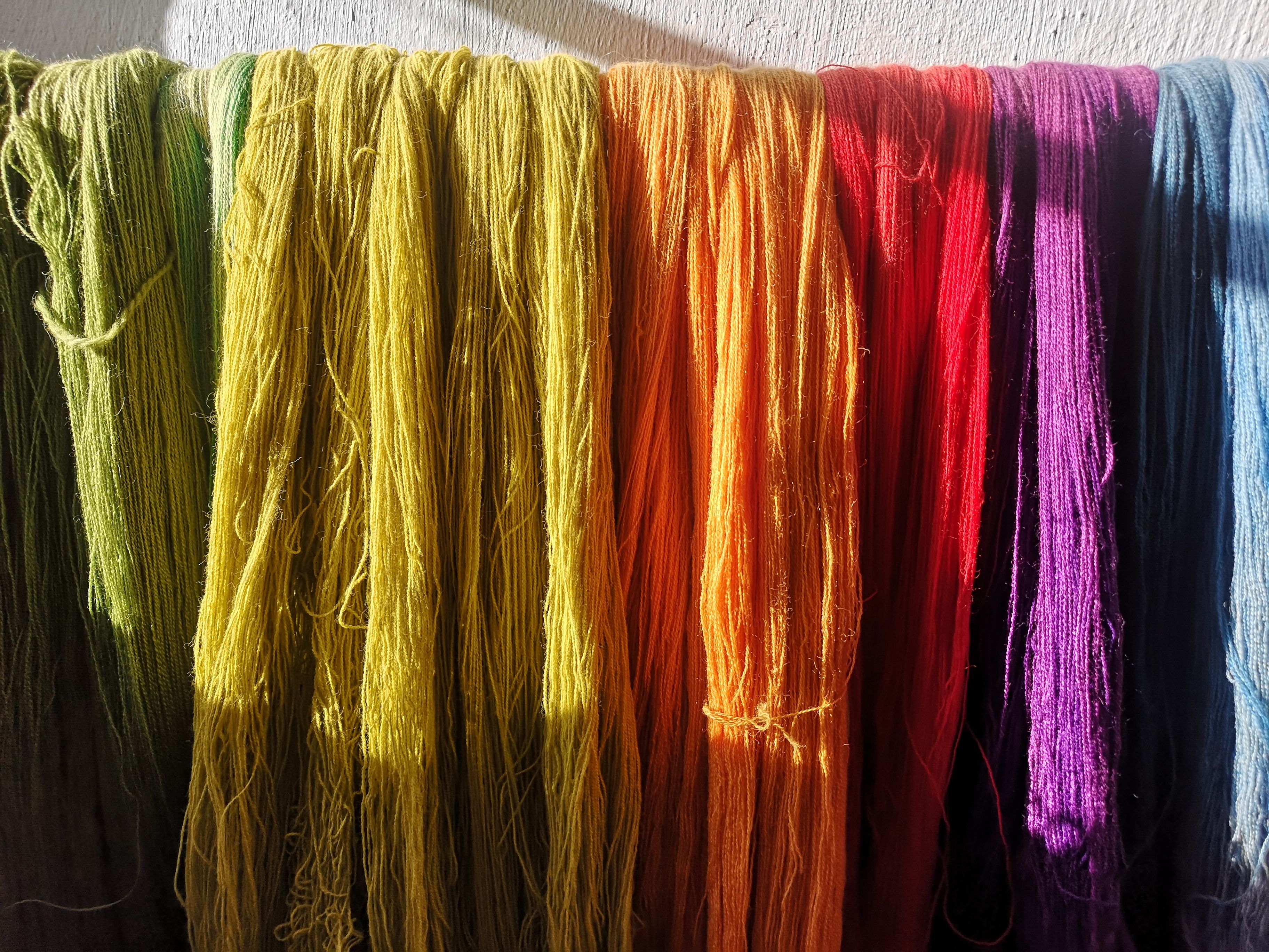 Yarn in various colors: green, yellow, orange, red, purple, and blue
