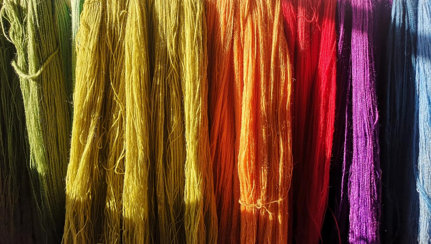 Yarn in various colors: green, yellow, orange, red, purple, and blue