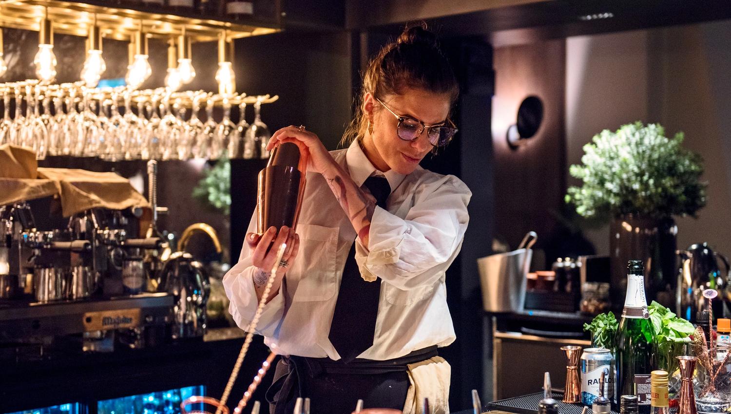 En bartender som mikser en drink bak en bar