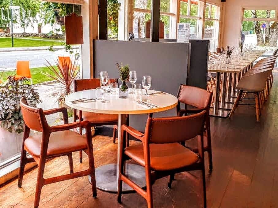 Lyst og moderne interiør på Gløyp Spiseri, med vindauge som slepp inn mykje dagslys og komfortable sitjeplassar.