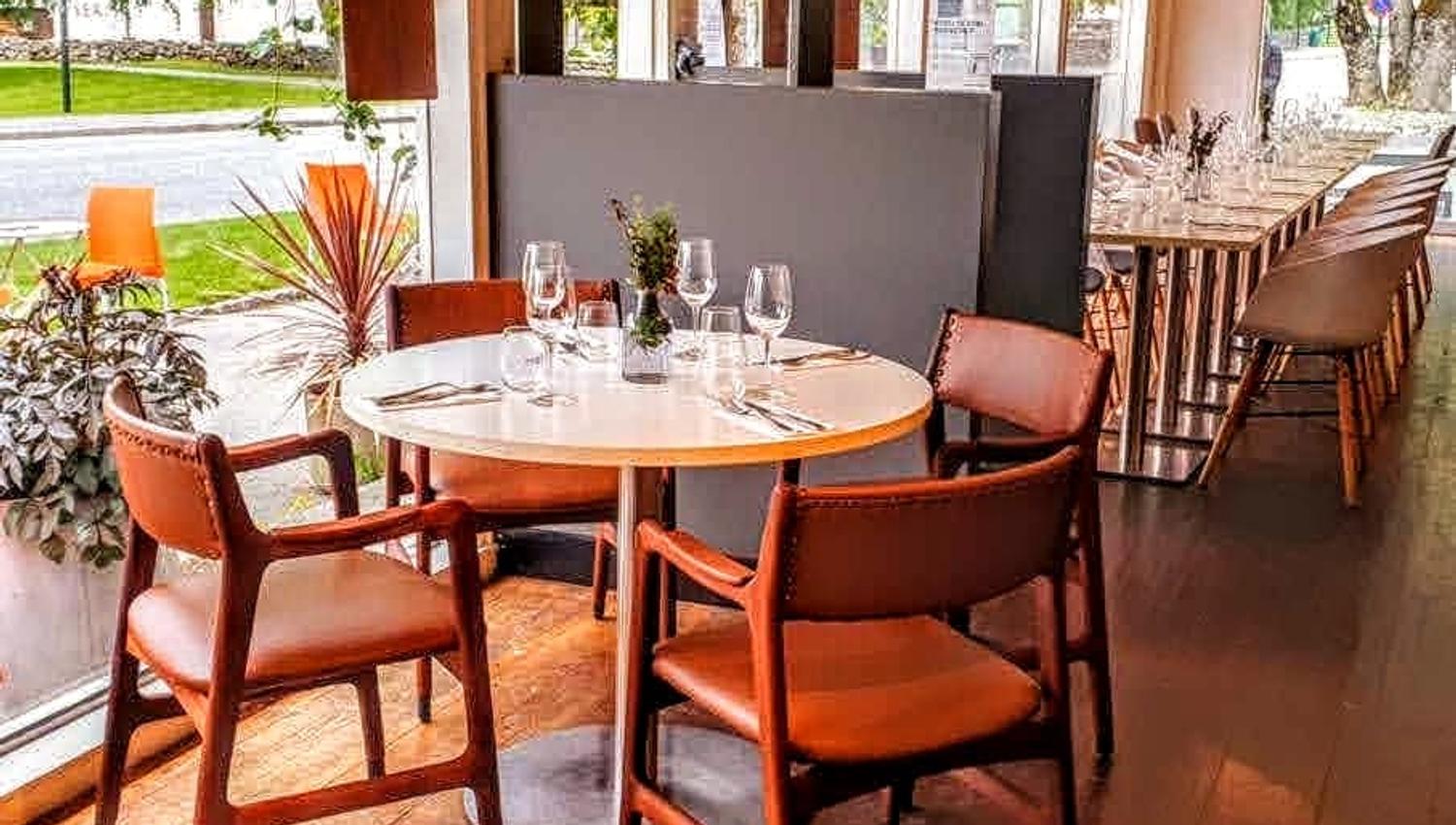 Lyst og moderne interiør på Gløyp Spiseri, med vindauge som slepp inn mykje dagslys og komfortable sitjeplassar.