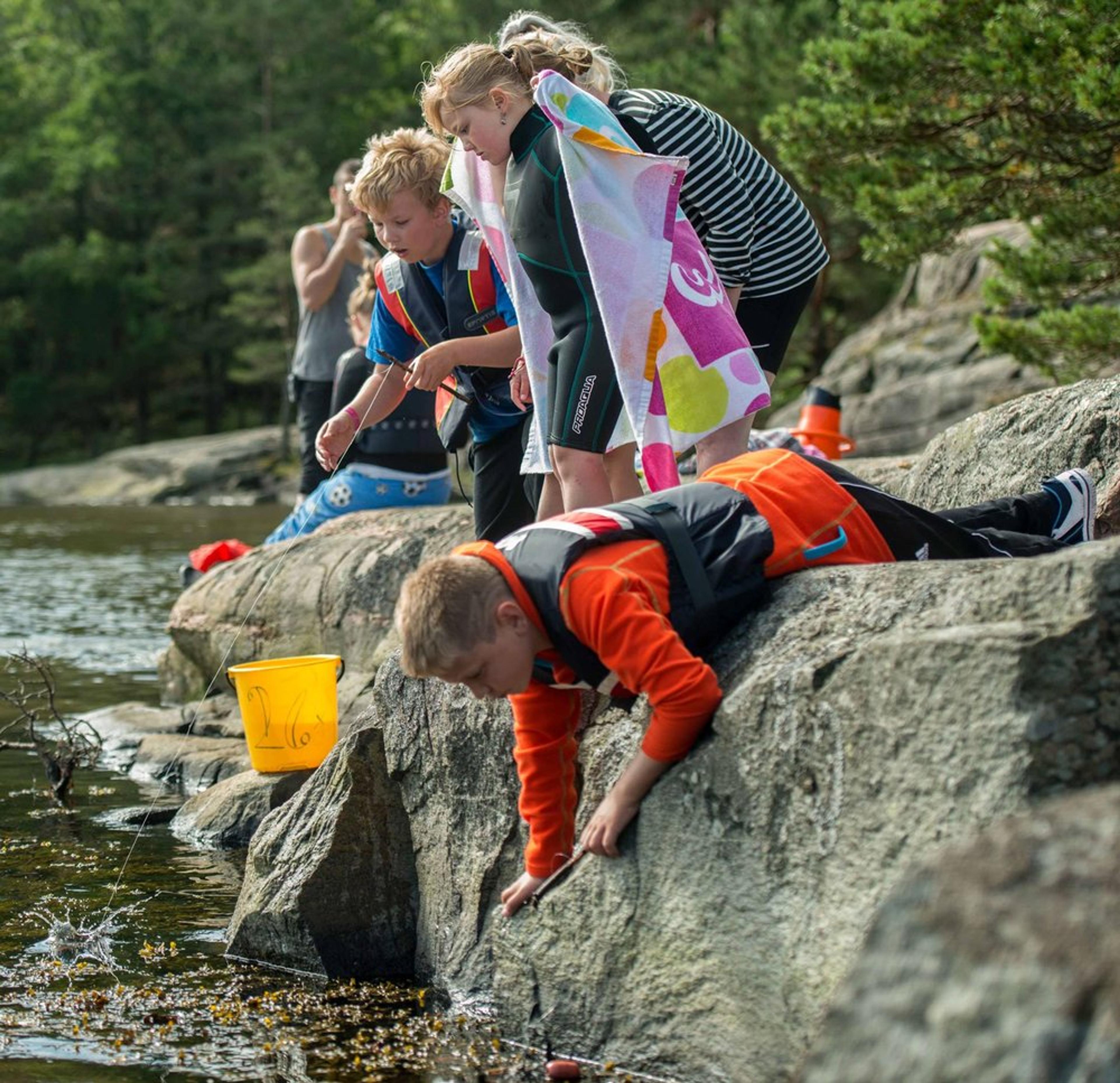 Barn som fisker i skjærgården