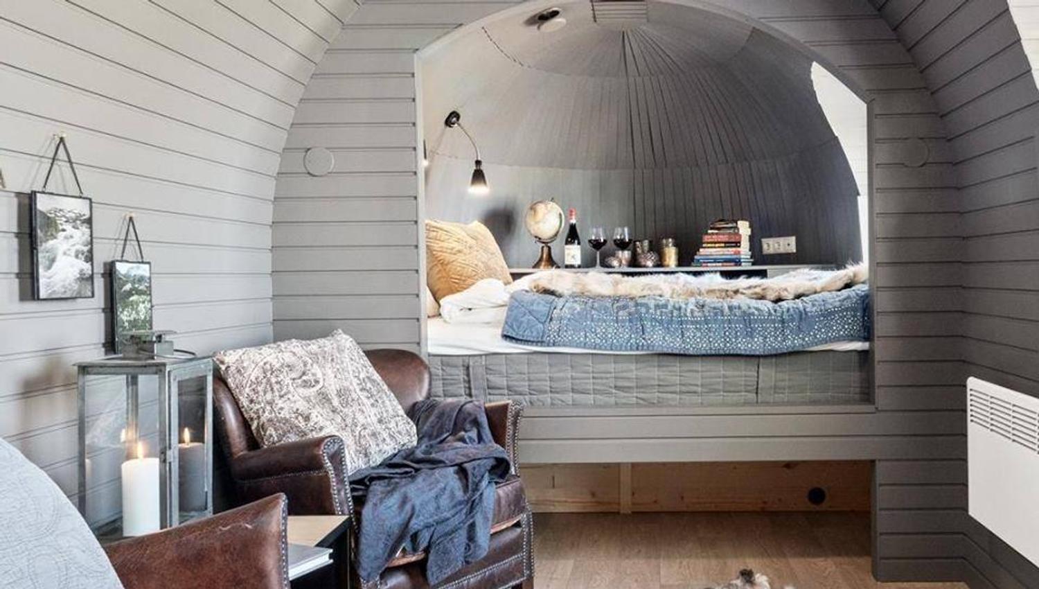 Bright modern interior of a wooden cabin pod with a bed and décor.