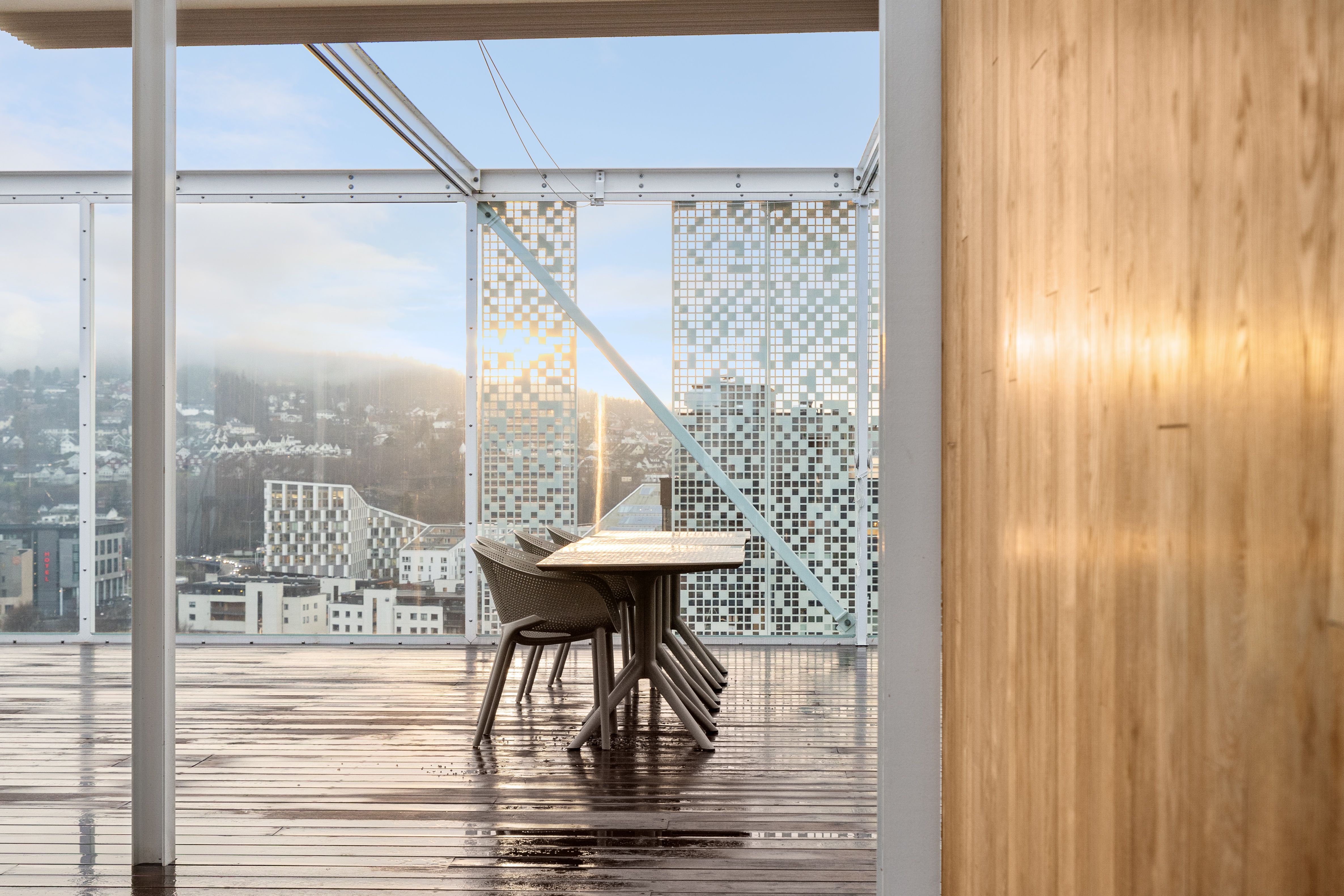 bilde med bord og stoler på en takterrasse