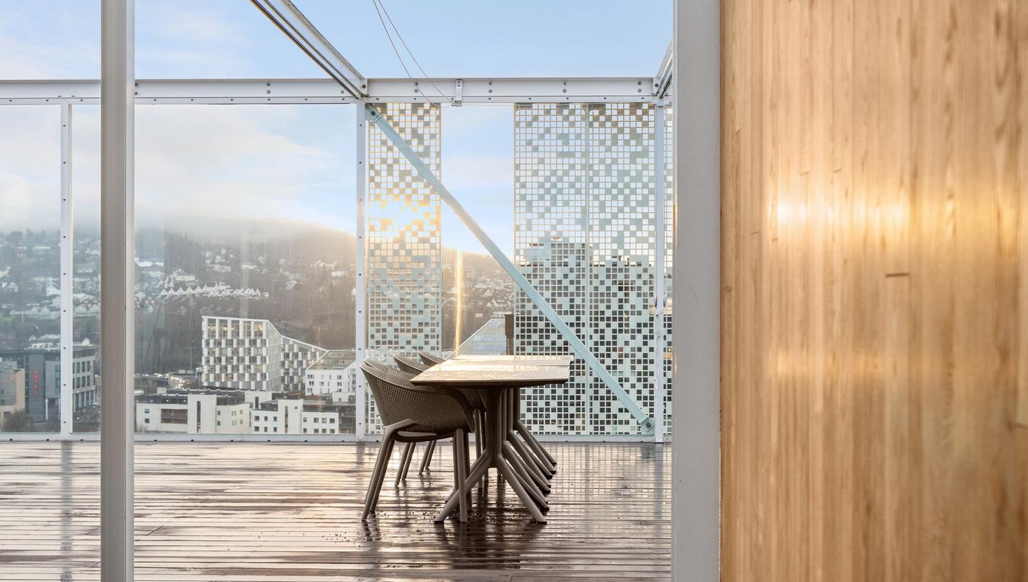 bilde med bord og stoler på en takterrasse