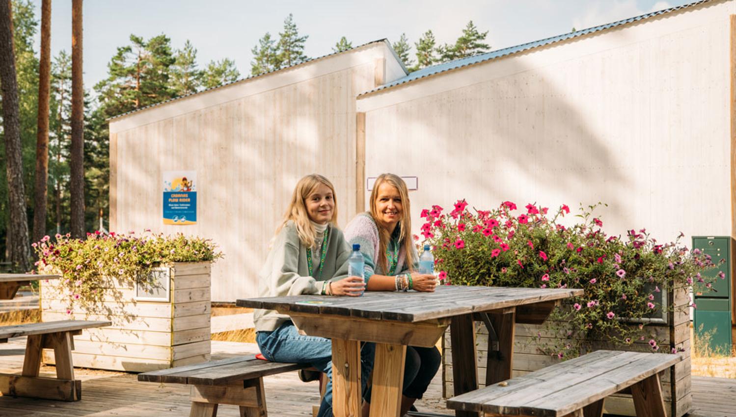 2 girls sitting on a picnic bench in one of the quiet areas in Bø Sommarland