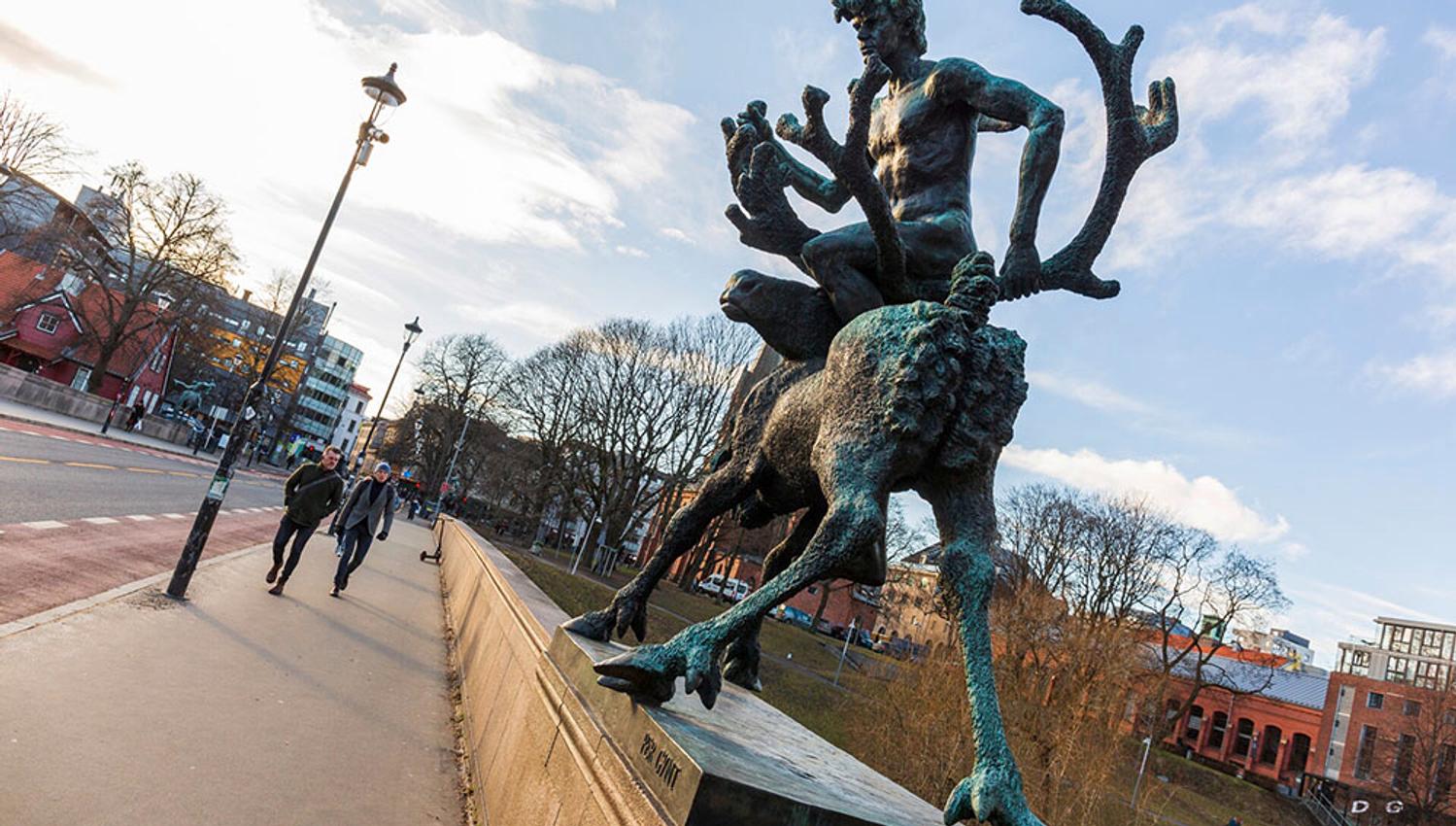 A statue of a man riding a moose on the bridge.