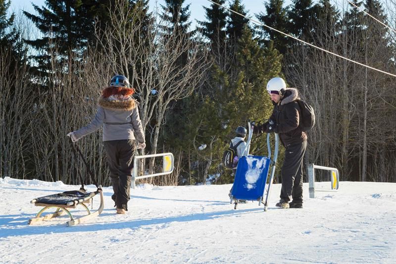 To personer som trekker hver sitt akebrett nederst i bakken.